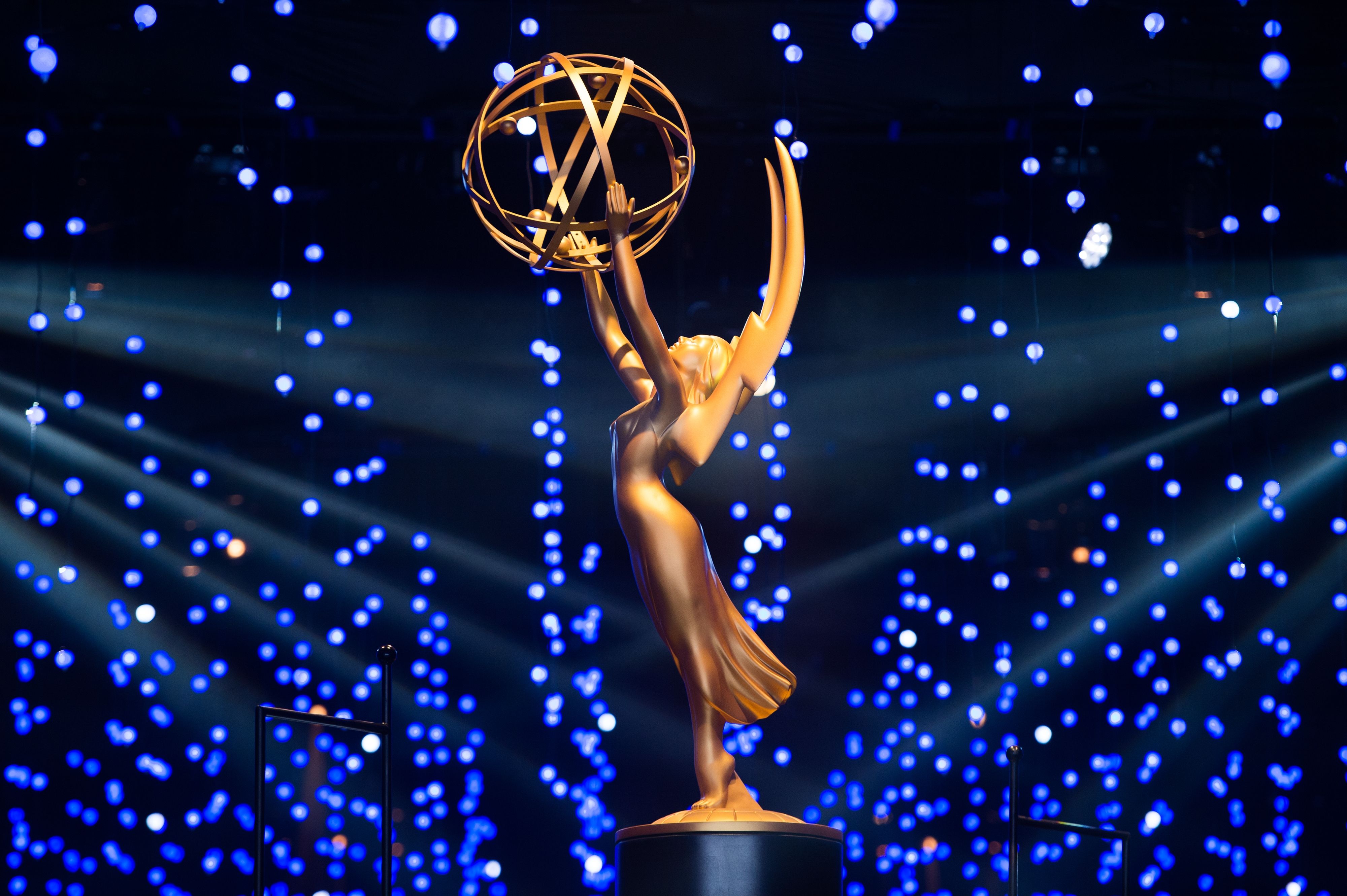 A gold Emmy statuette. The award looks like a woman in a dress with wings holding up a gold ball.