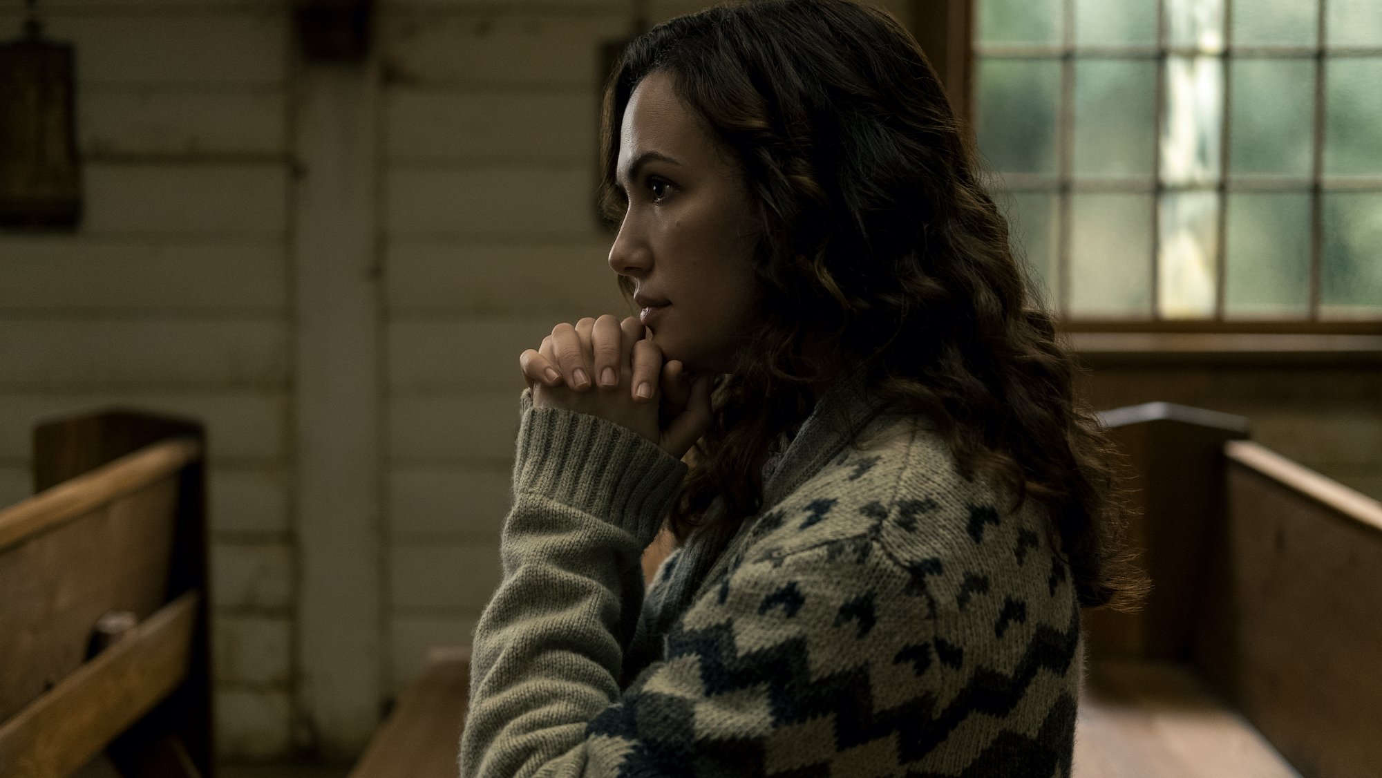 Kate Siegel as Erin Greene sitting in the Crockett Island church in the Netflix series 'Midnight Mass'