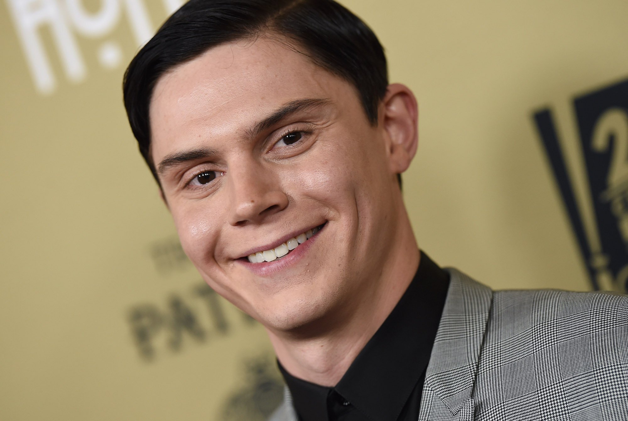 Evan Peters is wearing a plaid black and white suit with a black shirt to an 'American Horror Story' screening.