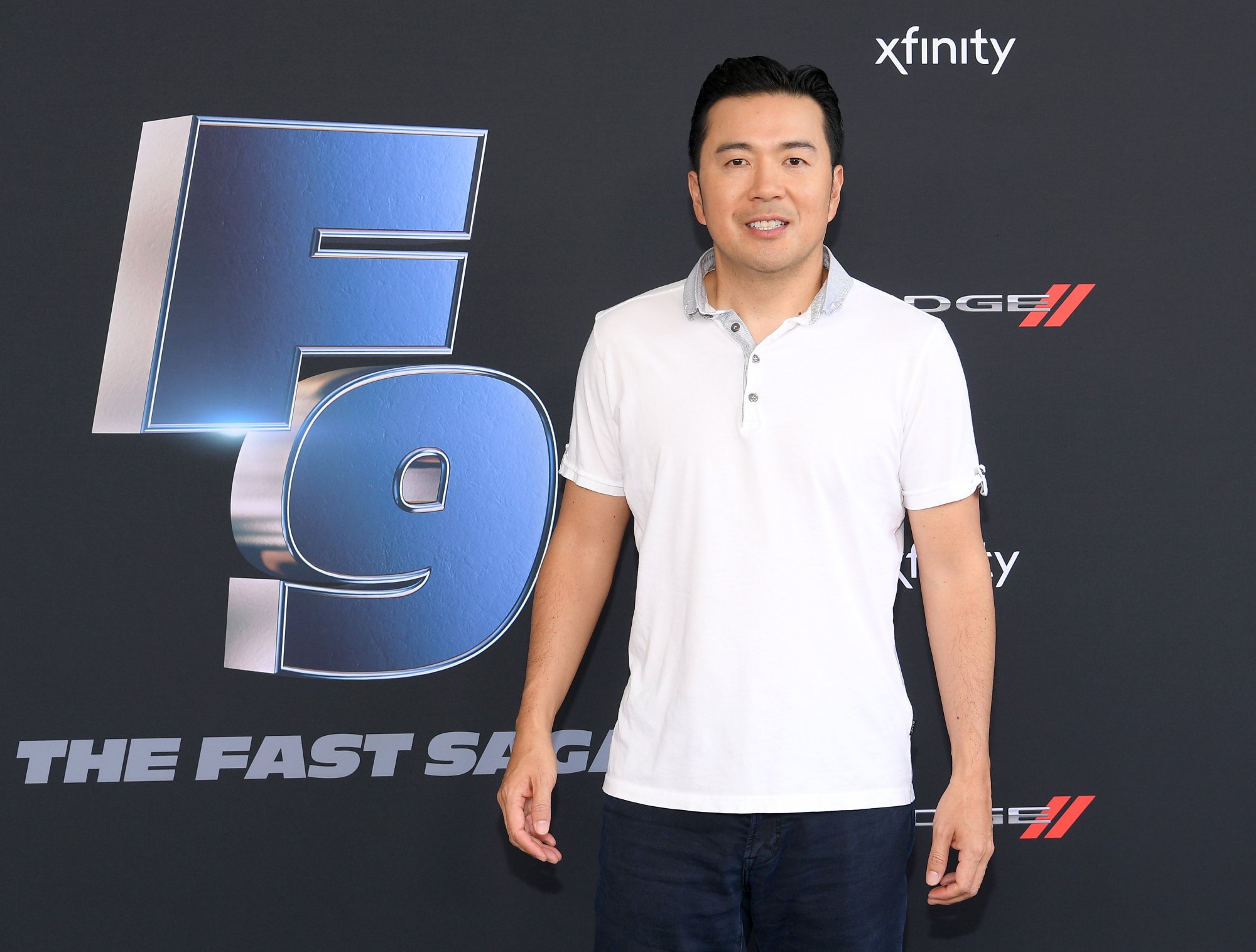'F9' director Justin Lin posing in a white collared shirt at The Road to F9 Global Fan Extravaganza