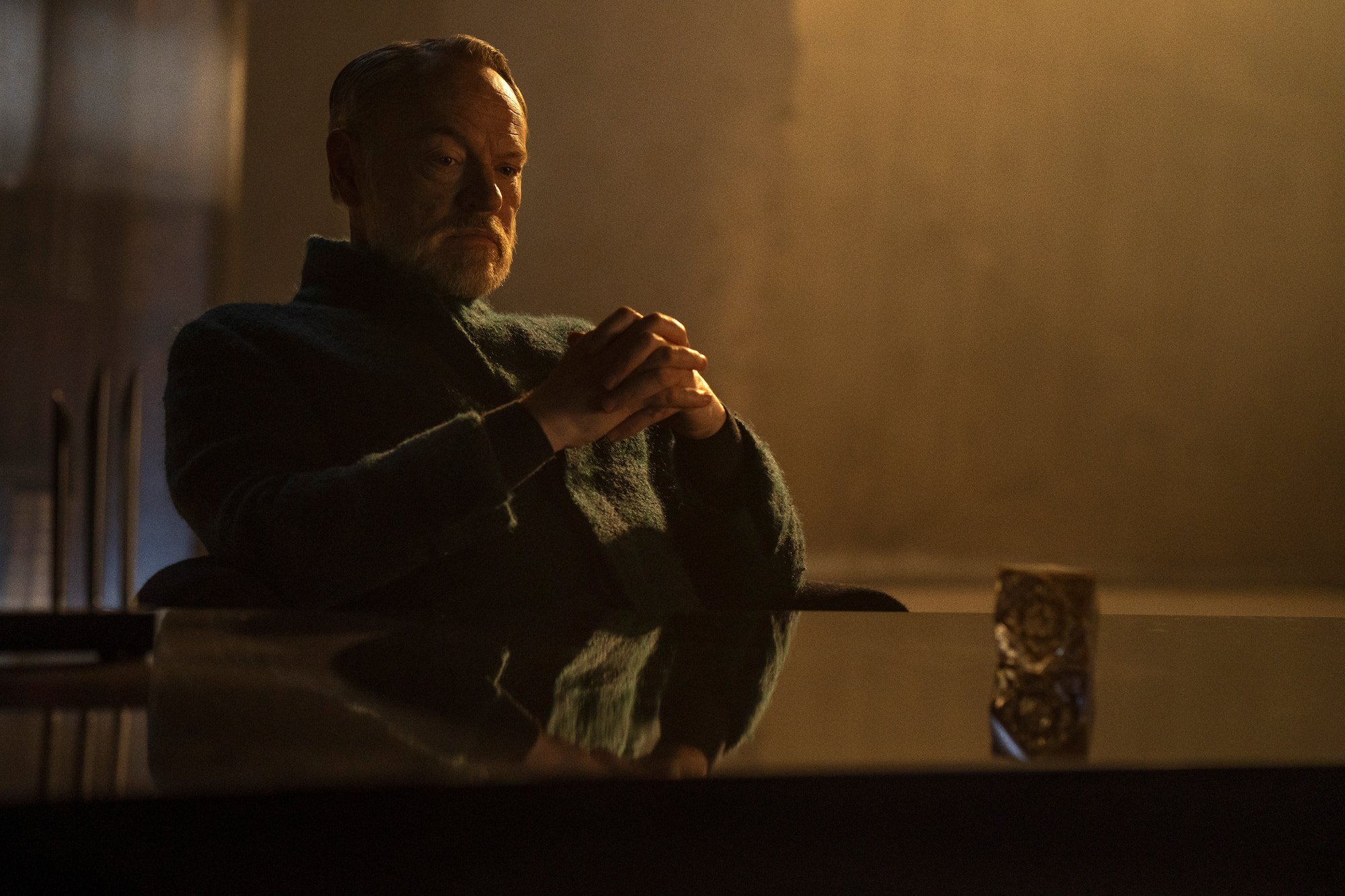 Foundation star Jared Harris sits with his hands folded on a table
