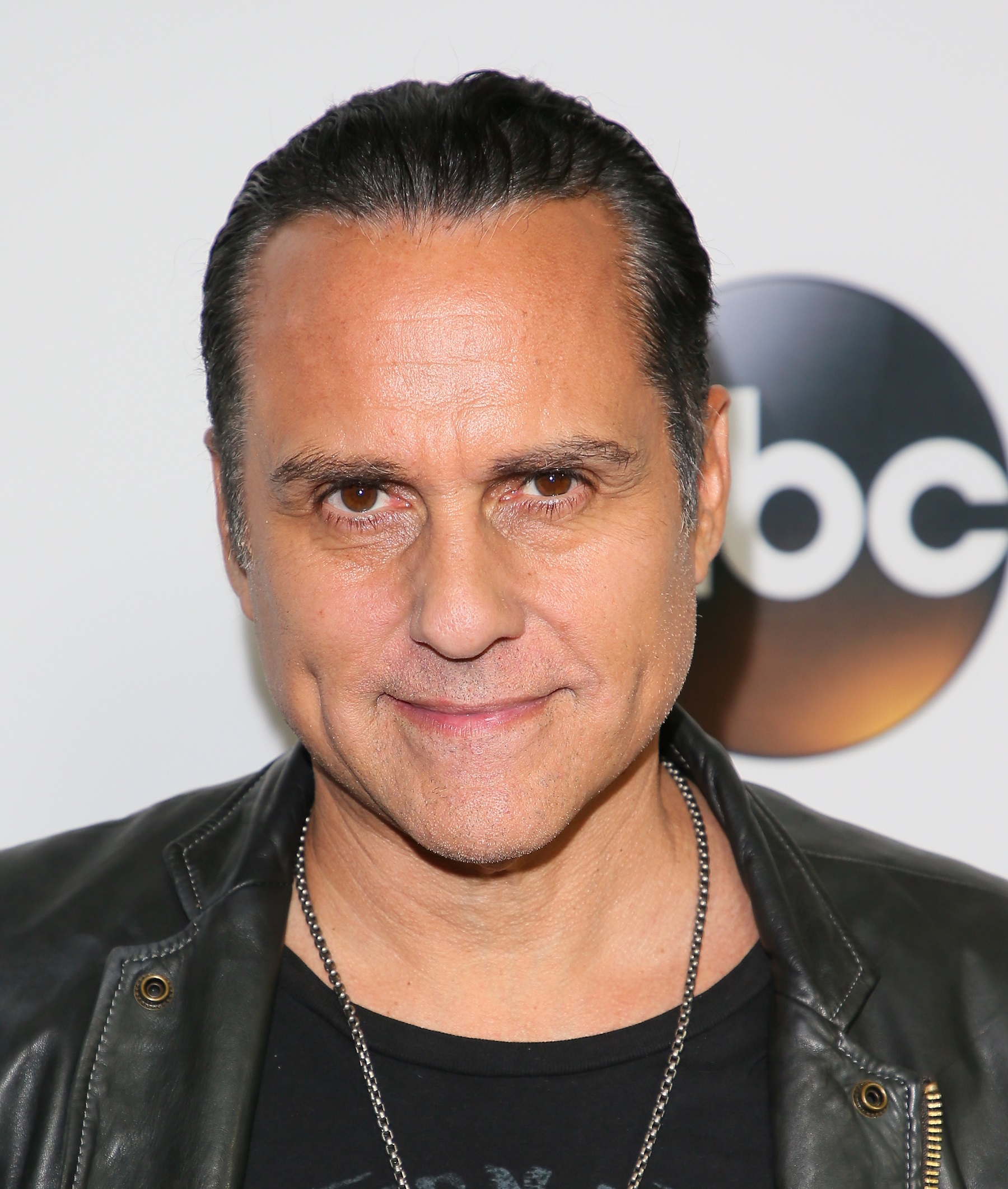 General Hospital star Maurice Benard is pictured here in a black leather jacket and a black t-shirt against an ABC step-and-repeat