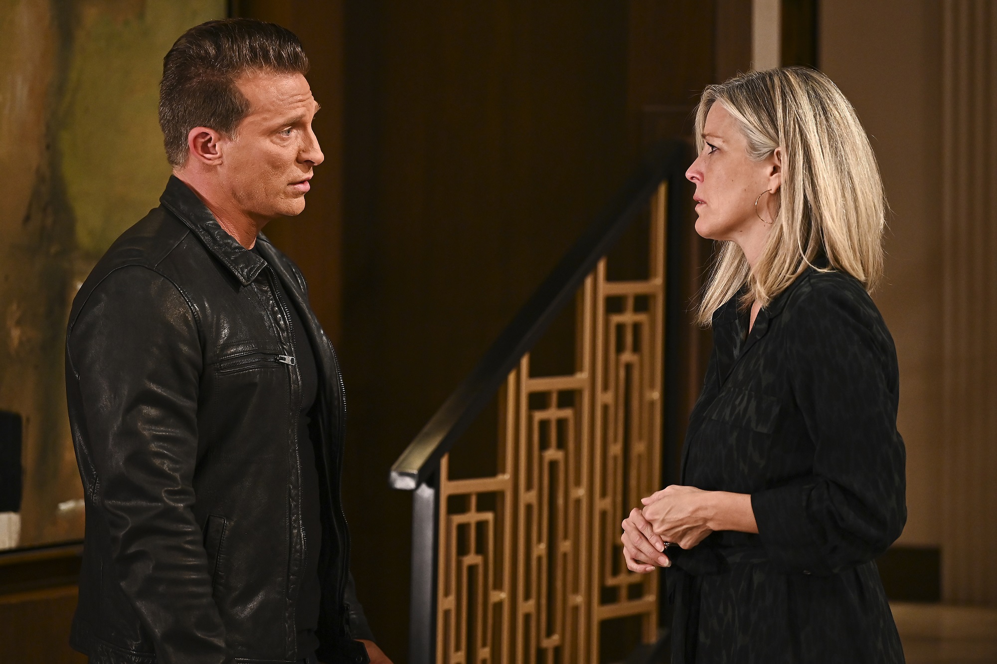 General Hospital speculation focuses on Carly and Jason, pictured here in all black clothing against a wood backdrop