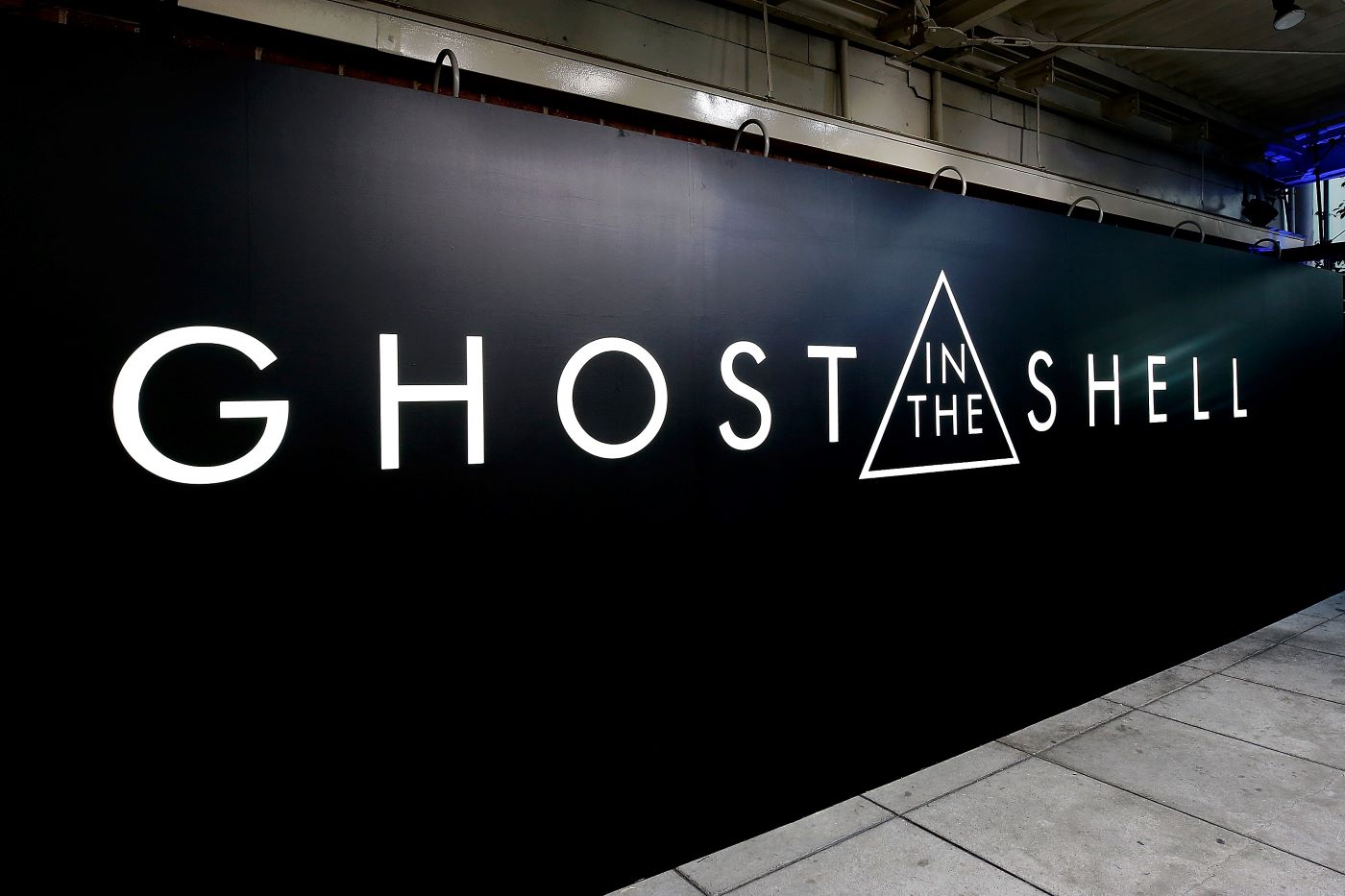 A black 'Ghost in the Shell' sign with white writing.