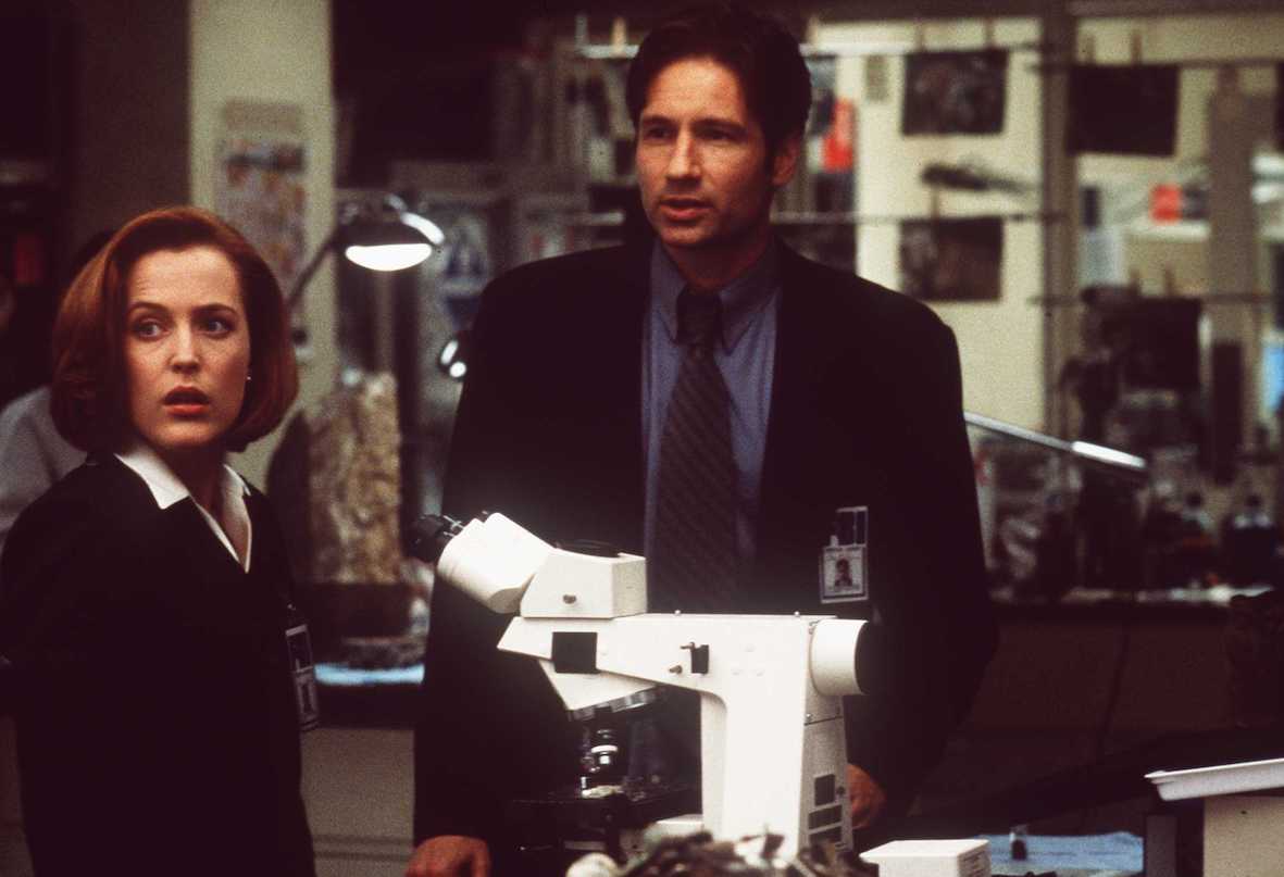 Gillian Anderson and David Duchovny look on near a microscope in 'The X-Files' movie