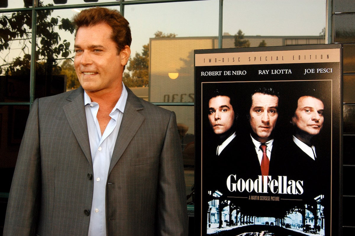 Ray Liotta standing next to a poster of 'Goodfellas'