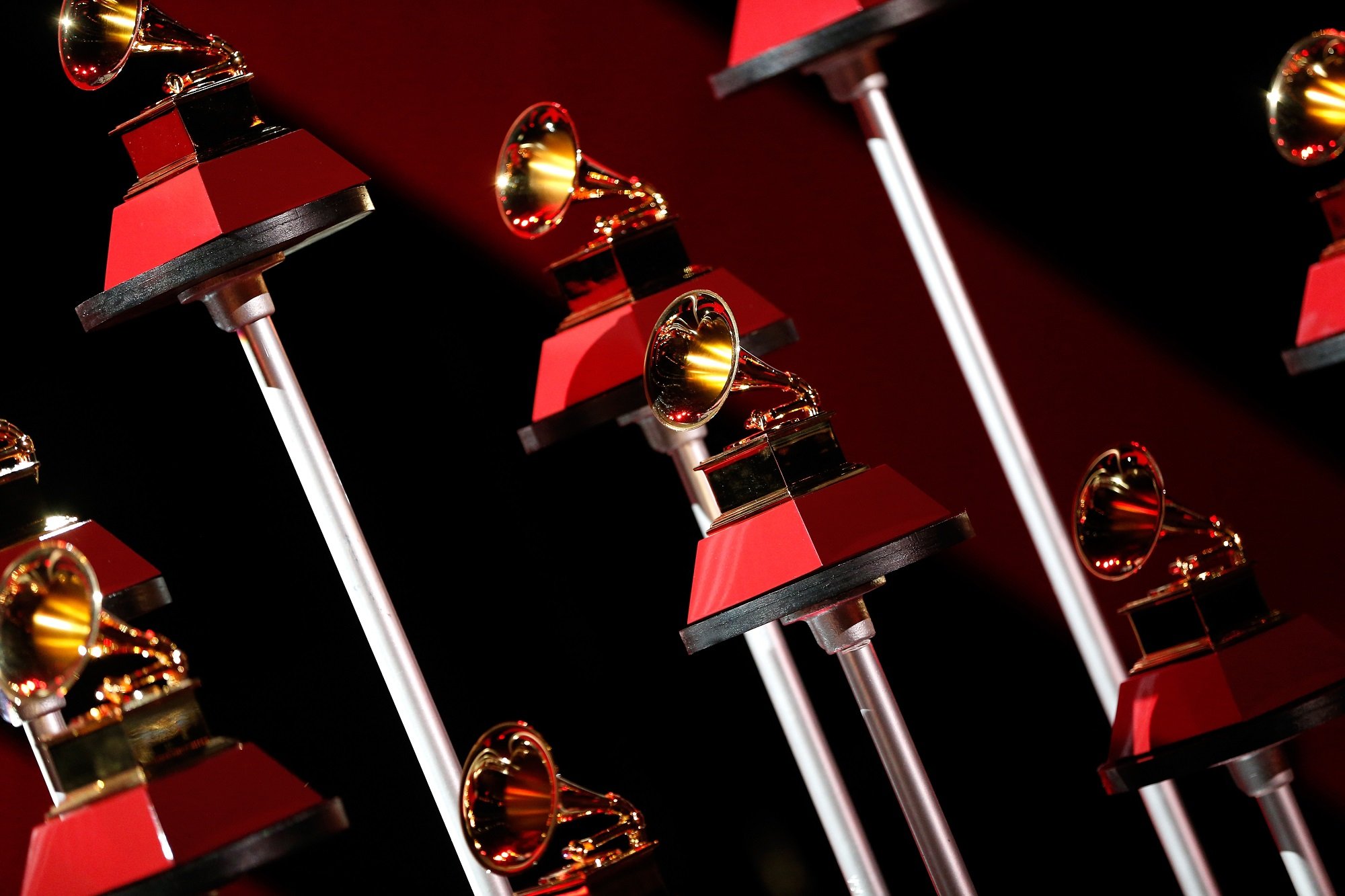 Multiple Latin Grammy award trophies on red pedestals