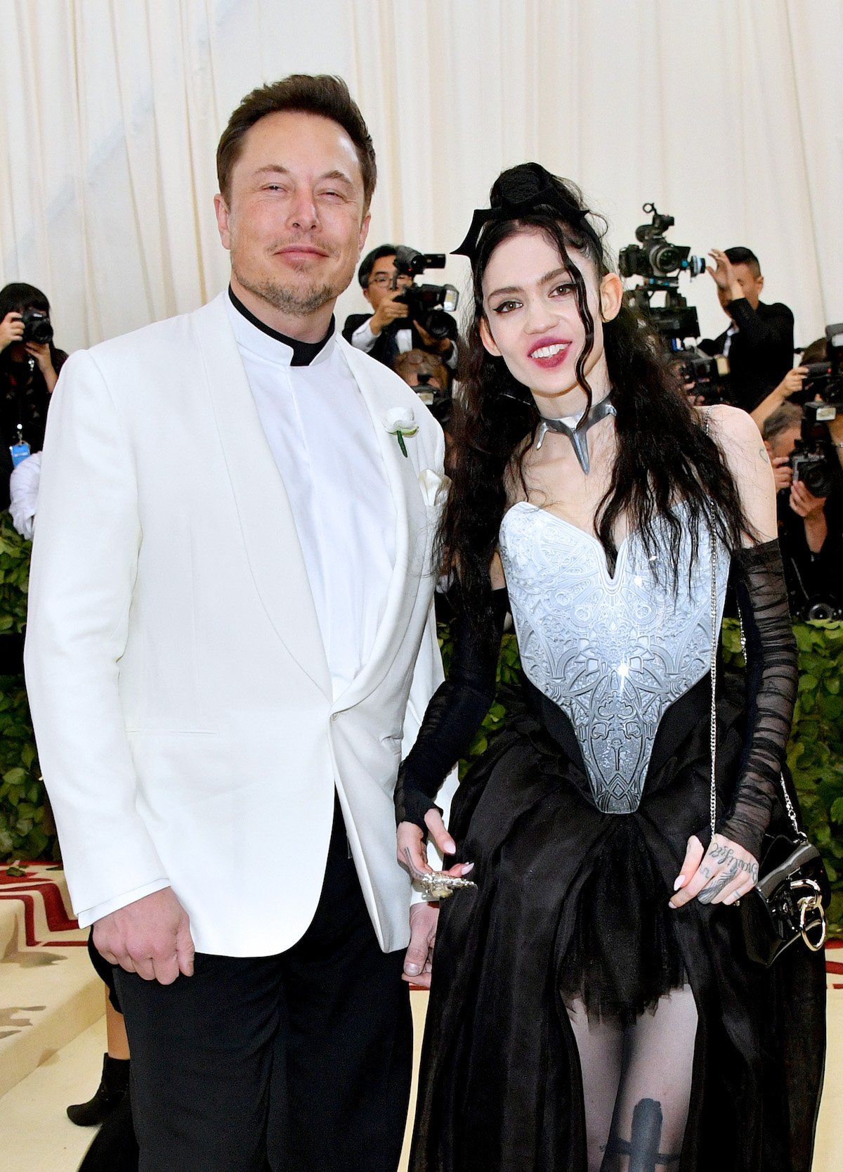 Elon Musk and Grimes smile for the camera together at the 2018 Met Gala.