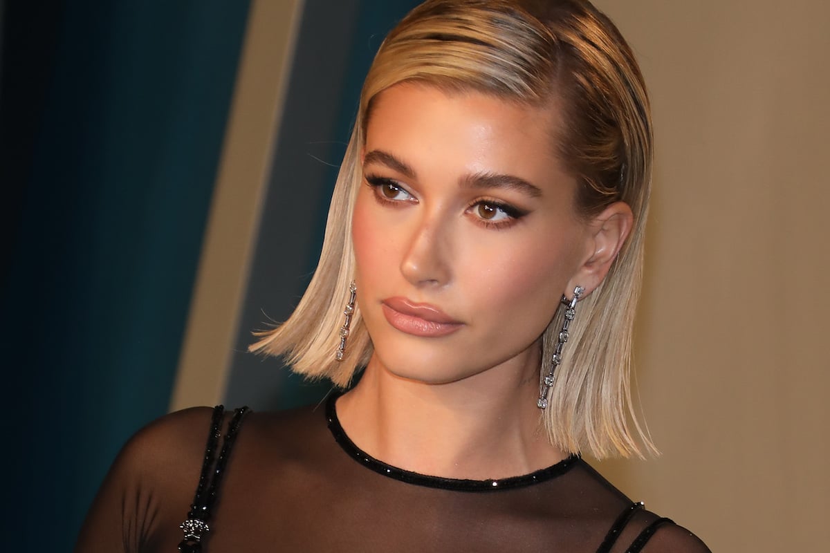 Hailey Bieber with short blonde hair posing for the camera at an event.