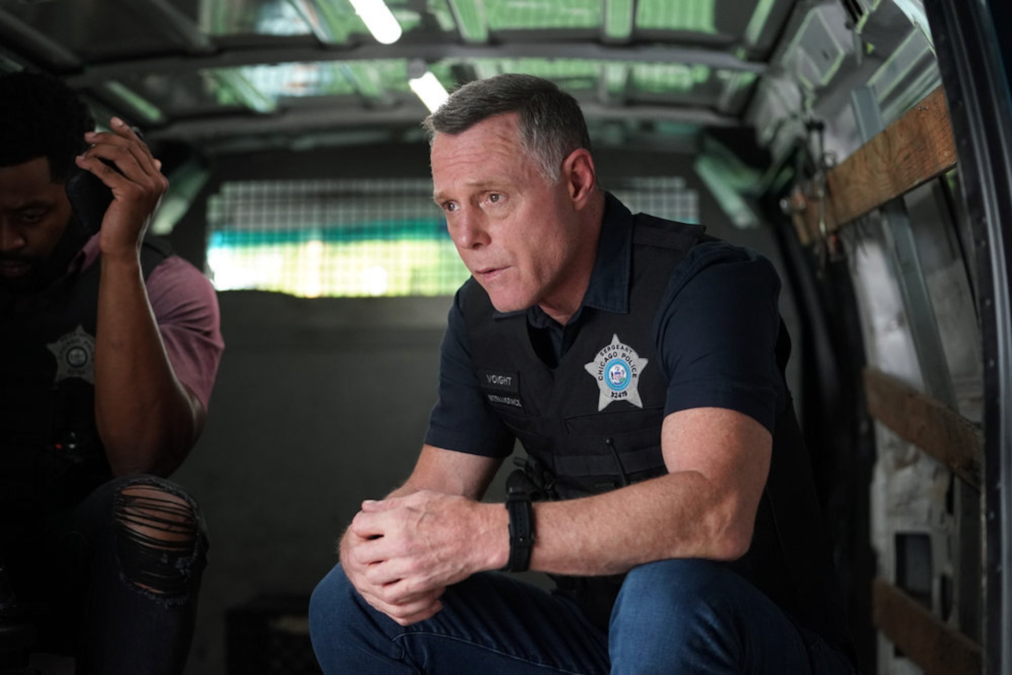 Hank Voight from 'Chicago P.D.' Season 9 sitting in uniform in a cop car