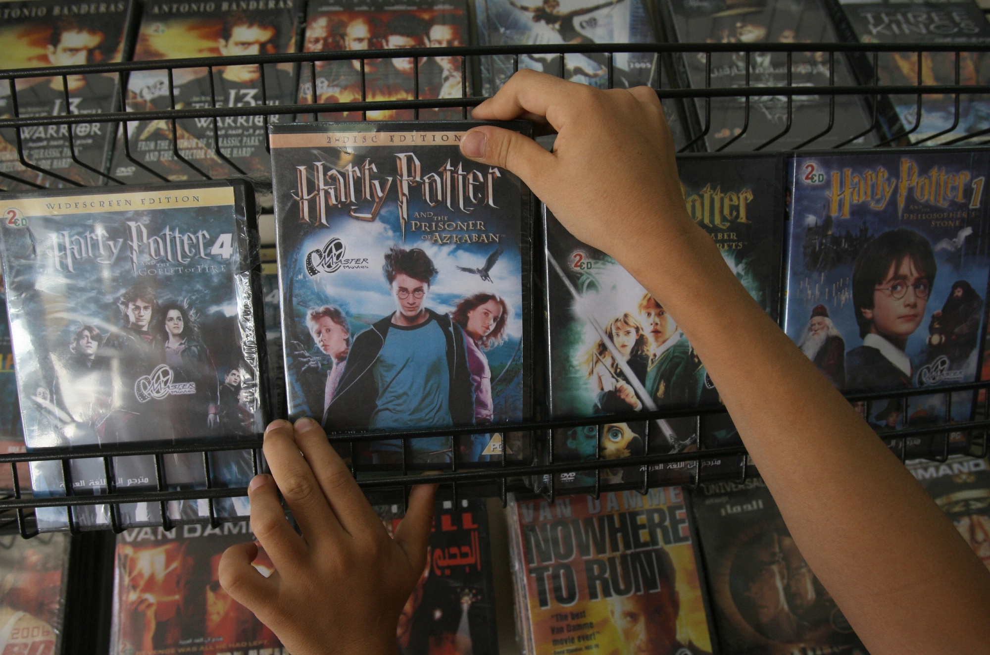 'Harry Potter' DVDs at a shop in Gaza City with a hand lifting one of the DVD cases on a shelf