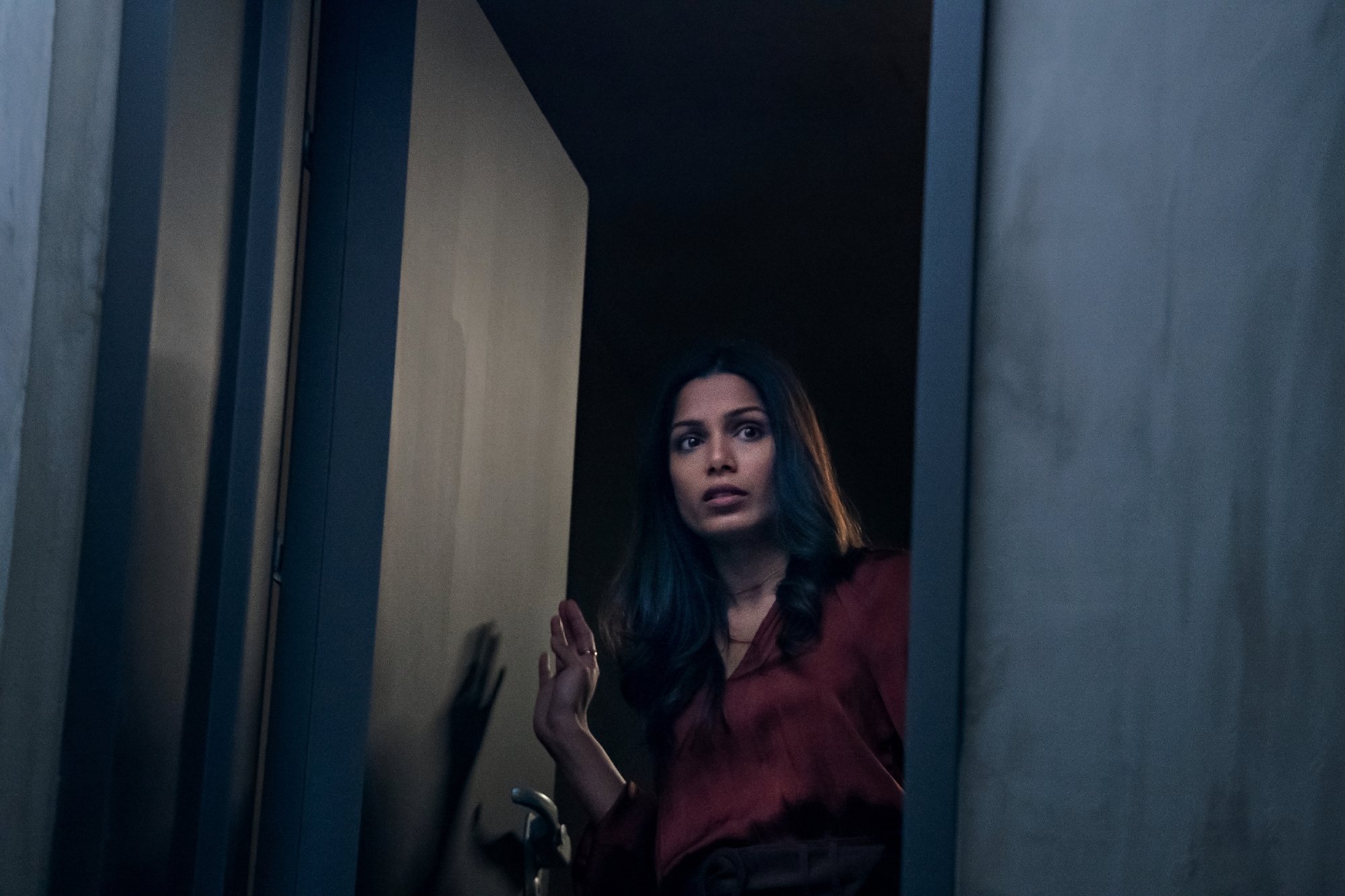 'Intrusion' star Freida Pinto as Meera in the Netflix movie creeping around wearing red