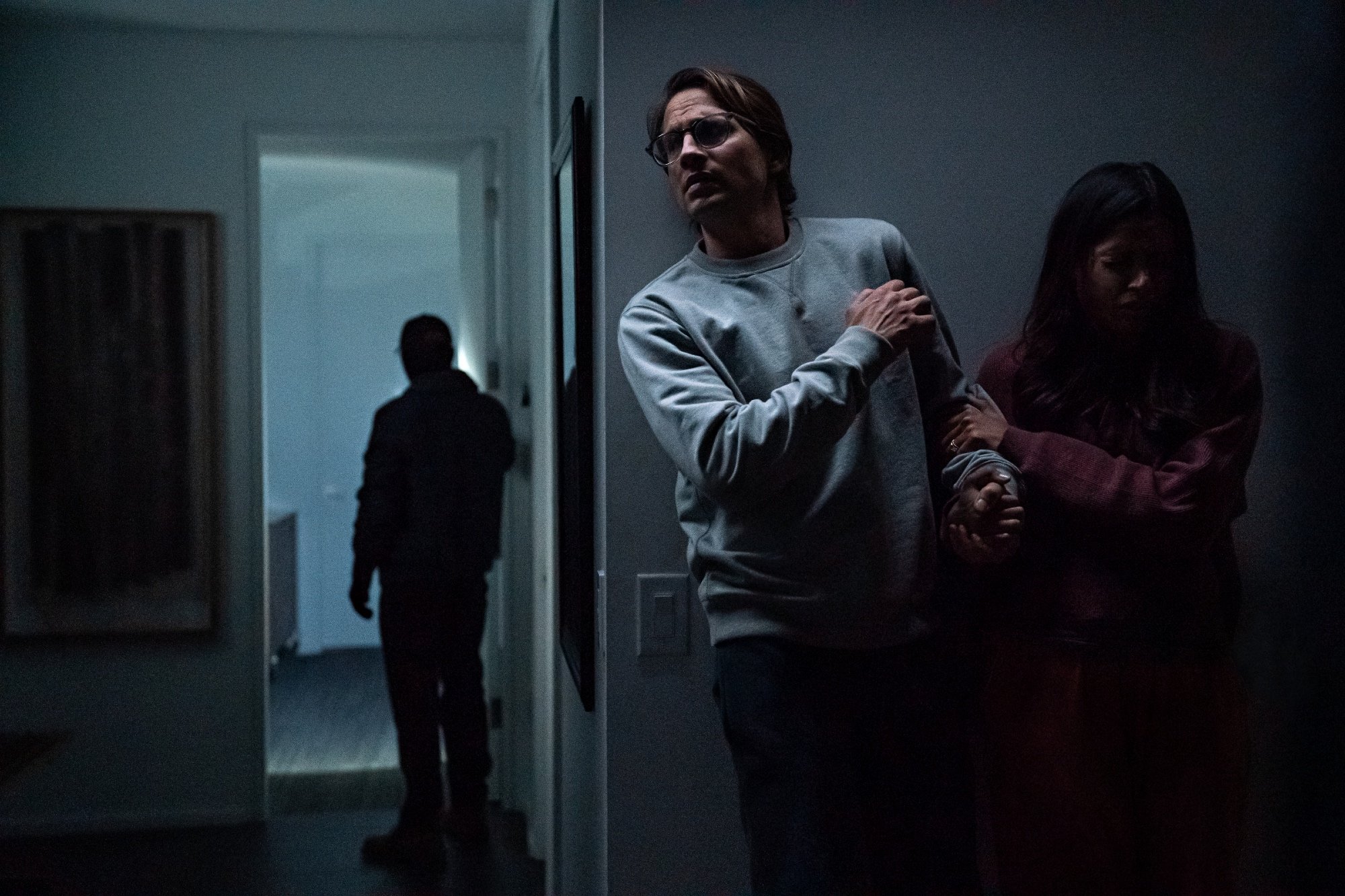 'Intrusion' stars Logan Marshall-Green as Henry and Freida Pinto as Meera hiding behind a wall from an intruder