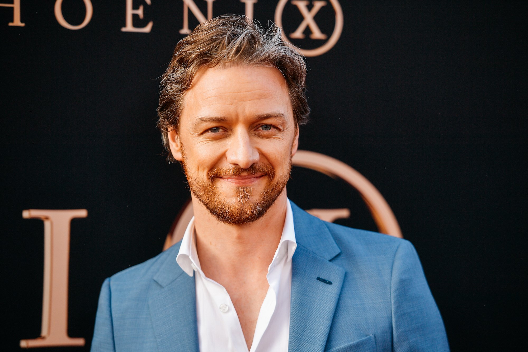 James McAvoy smiling in front of a black background