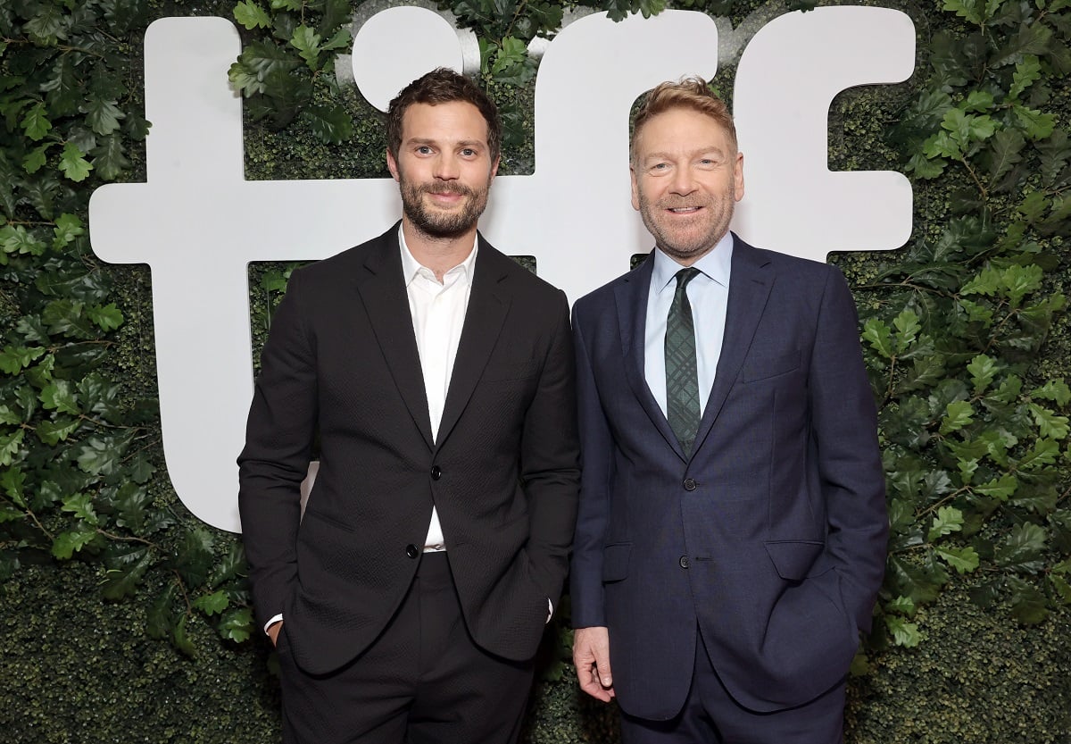 Jamie Dornan and Kenneth Branagh smile at the camera at festival. 
