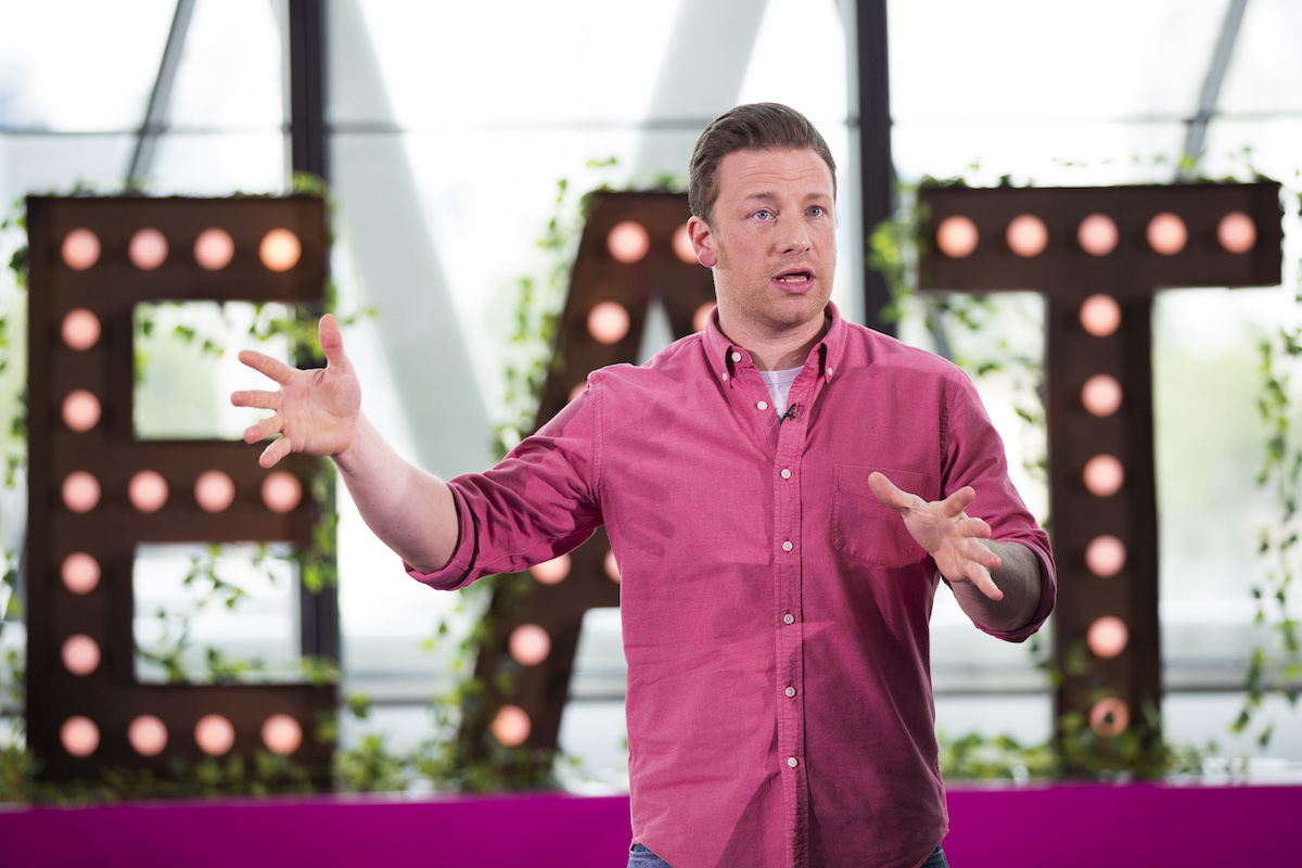 Jamie Oliver speaks while wearing a pink button down shirt during Jamie Oliver Presents Food Revolution Day in 2014
