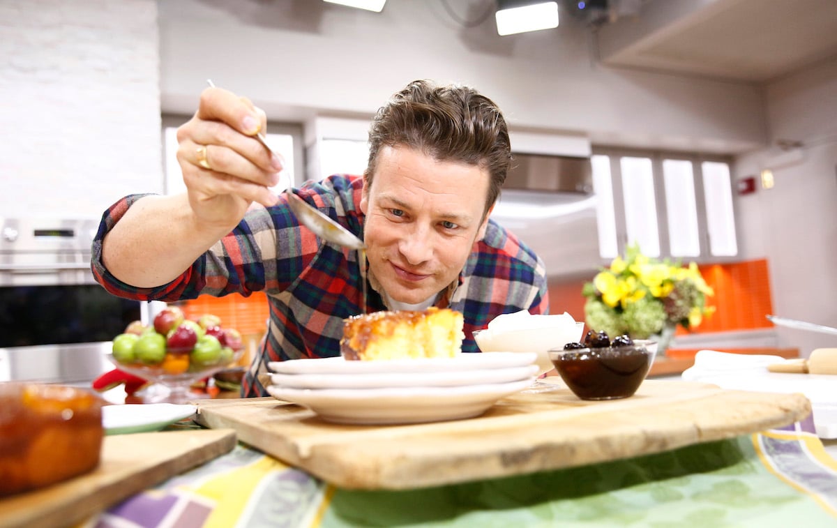 Jamie Oliver spoons a sauce on food wearing a plaid shirt on 'Today'