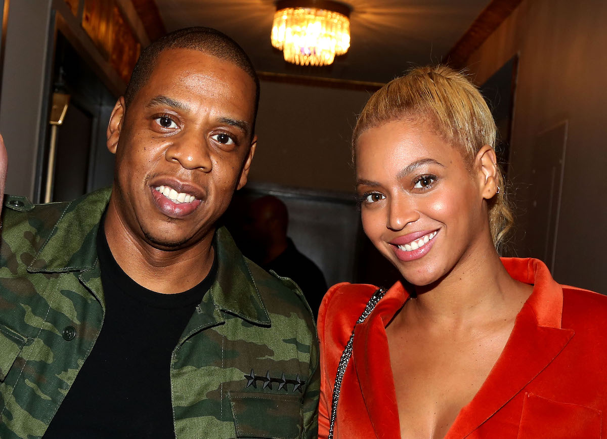 Jay-Z and Beyonce are dressed casually and smiling for the camera.