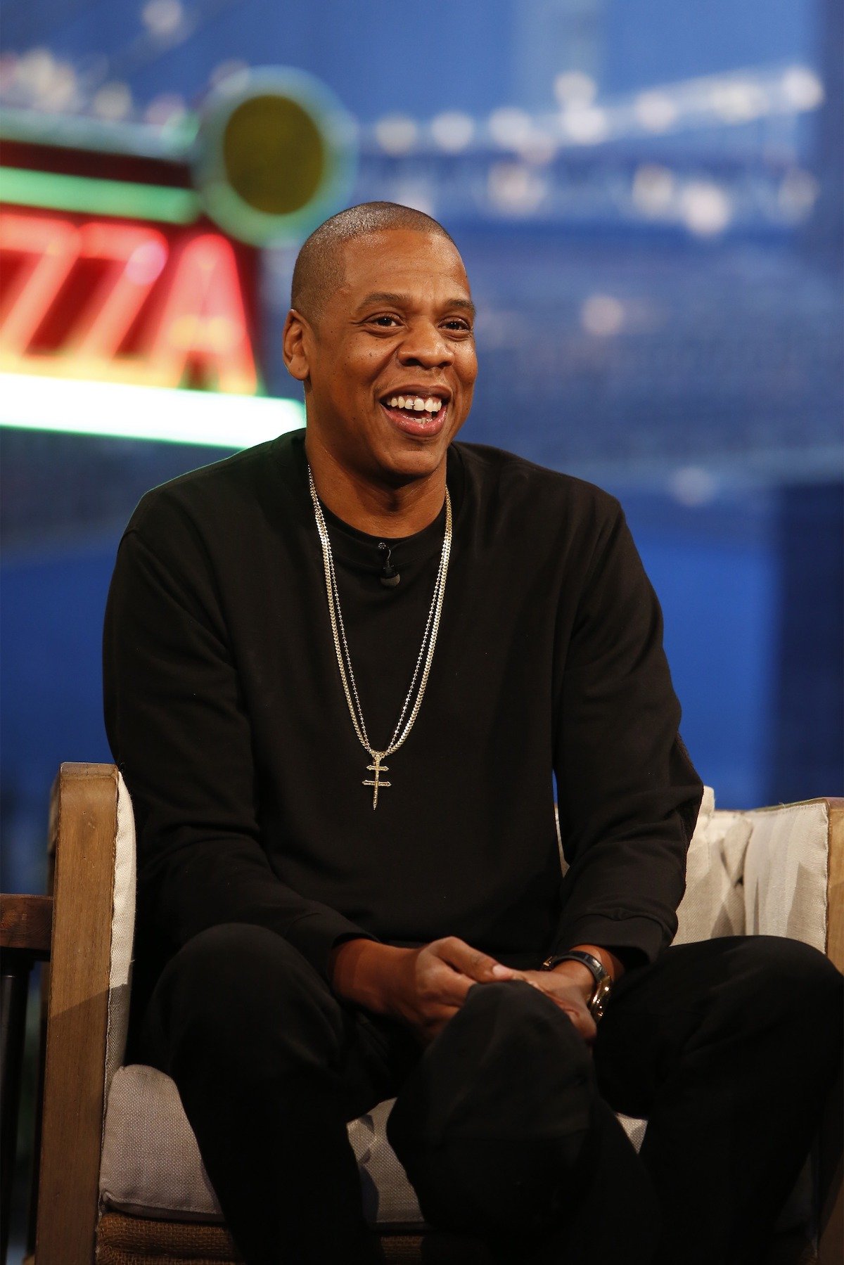 Jay-Z smiles while being interviewed on stage.