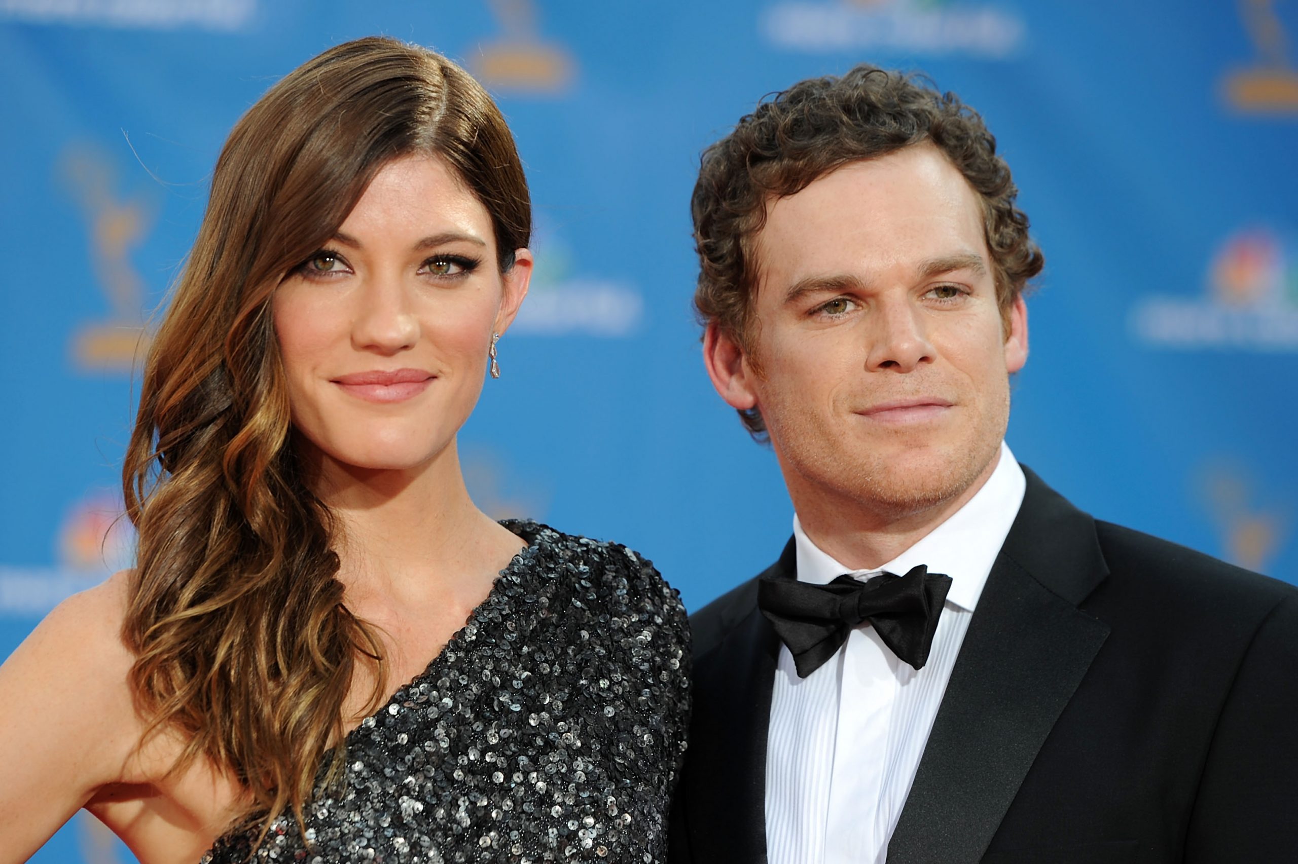 Jennifer Carpenter and Michael C. Hall pose for a photo. Carpenter wears a sequined one-shoulder dress and Hall wears a tux with a bow tie.
