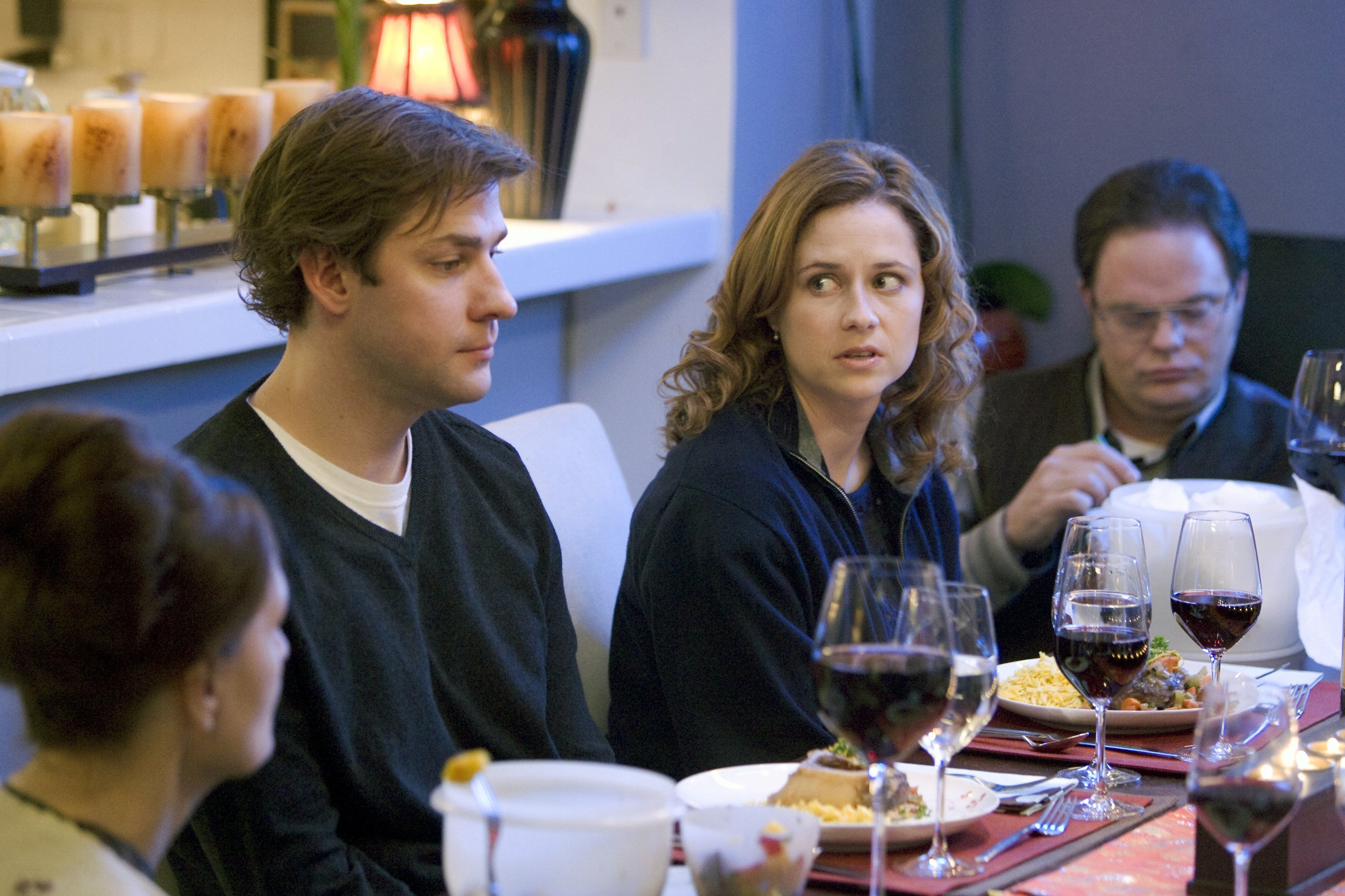 John Krasinski as Jim Halpert, Jenna Fischer as Pam Beesly, Rainn Wilson as Dwight Schrute sitting at the dining room table in 'The Office' Season 4 episode 'The Dinner Party'