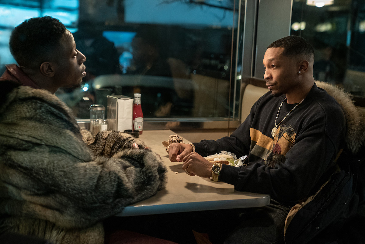 Joey Bada$$ as Unique and Malcolm Mays as Lou Lou conversing at a diner in 'Power Book III: Raising Kanan'