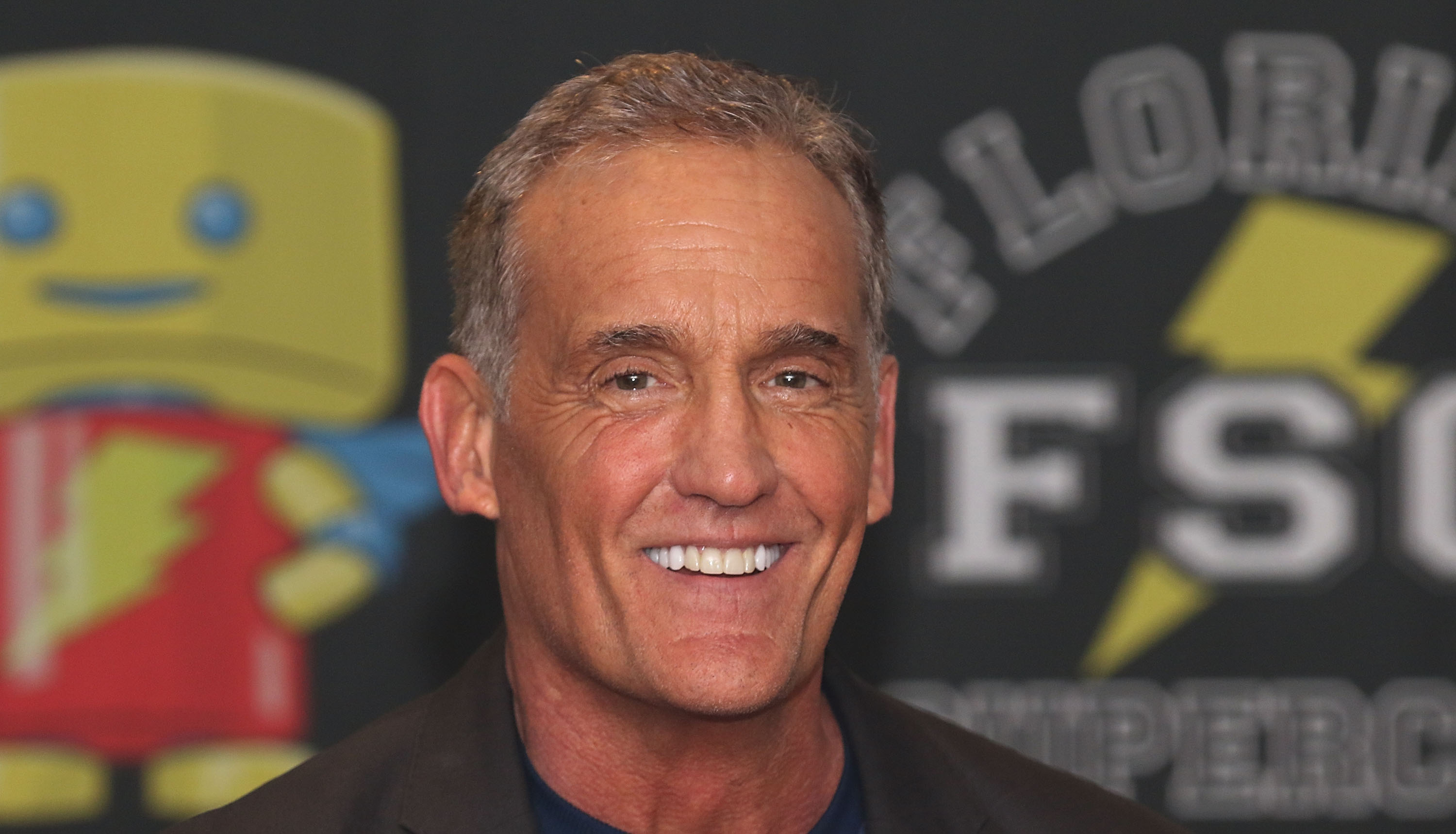 'Stargirl' actor John Wesley Shipp wears a suit and smiles for cameras.