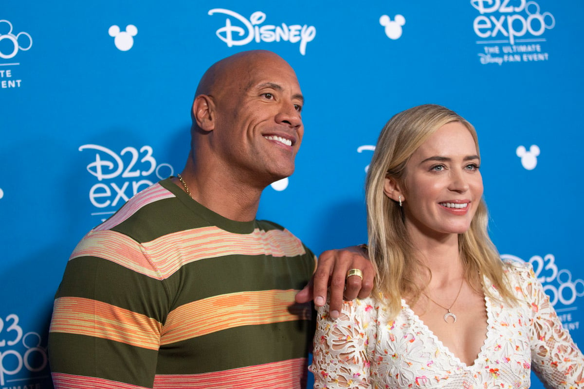 Dwayne Johnson and Emily Blunt with blue D23 background