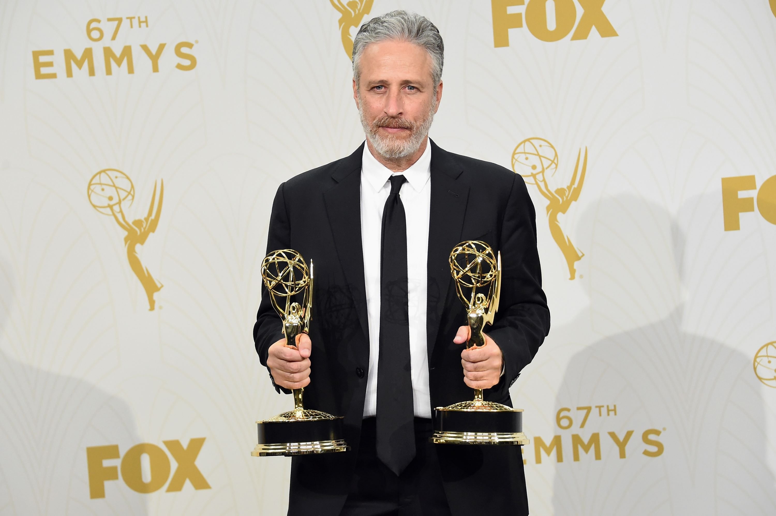 Jon Stewart posing with awards.