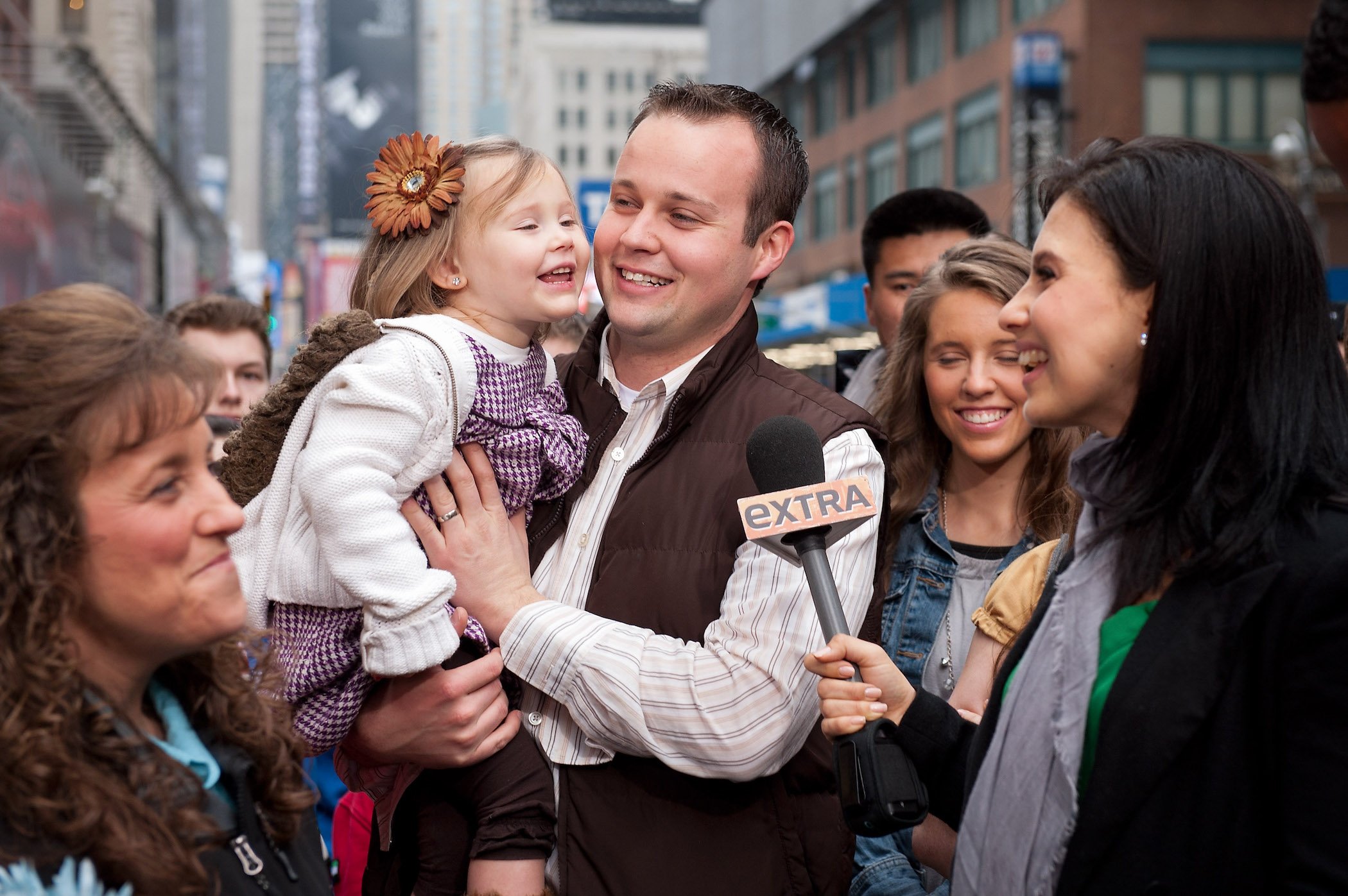 Josh Duggar and his daughter during their visit with 'Extra' in Times Square, surrounded by the rest of the Duggar family