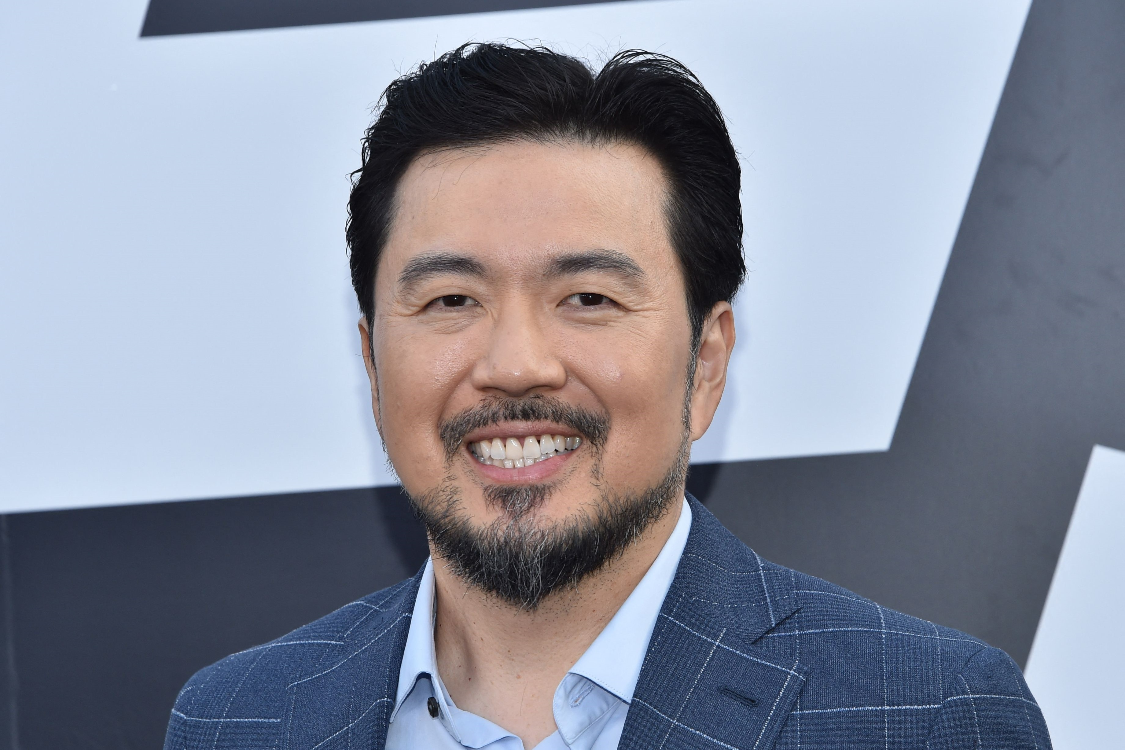 Justin Lin, in a blue checkered suit, at the TCL Chinese Theatre for the premiere of 'F9: The Fast Saga' in 2021.