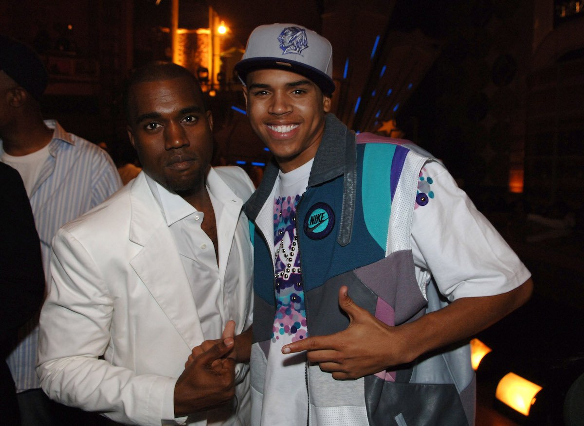 Kanye West and Chris Brown smile and pose together at an event.