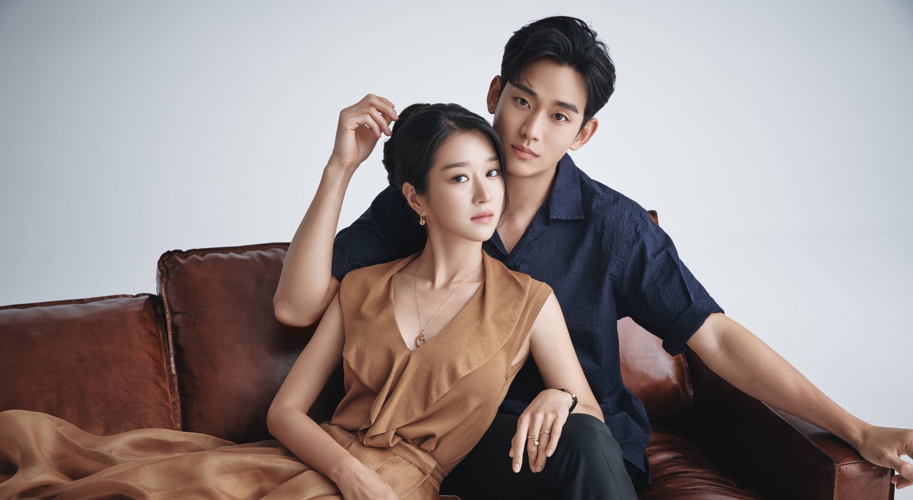 Kim Soo-Hyun and Seo Yea-Ji for 'It's Okay to Not Be Okay' wearing brown dress and black suit on leather couch.
