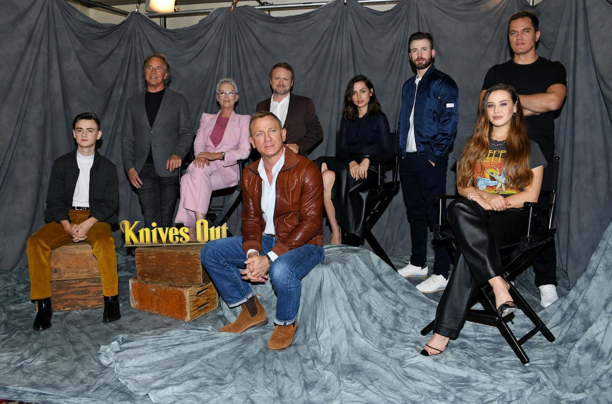 Jaeden Martell, Don Johnson, Jamie Lee Curtis, Rian Johnson, Daniel Craig, Chris Evans, Ana de Armas, Michael Shannon, and Katherine Langford of 'Knives Out' pose in front of a grey backdrop. 'Knives Out 2' filming wrapped in September 2021 and will star Craig with a new cast.