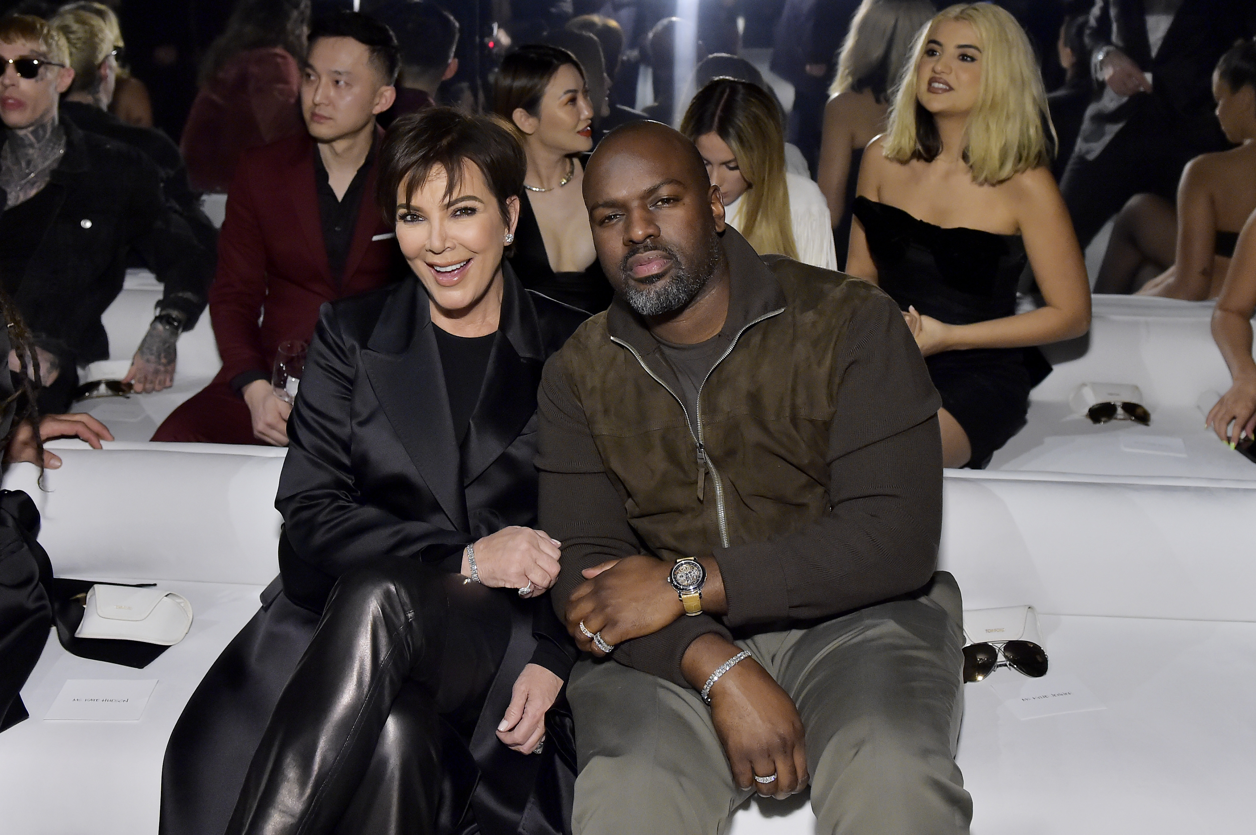Kris Jenner and boyfriend, Corey Gamble, sitting front row at a fashion show.