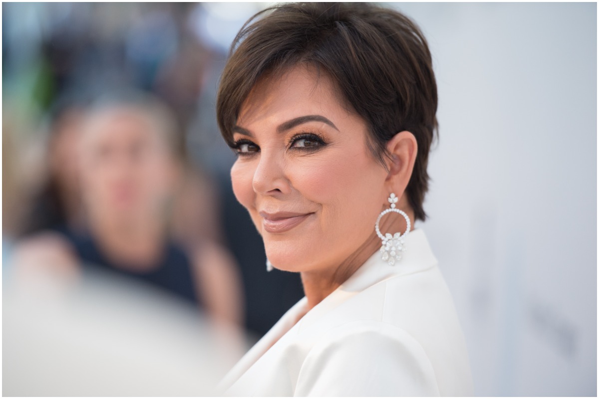 Kris Jenner smiling at the camera while on the red carpet.