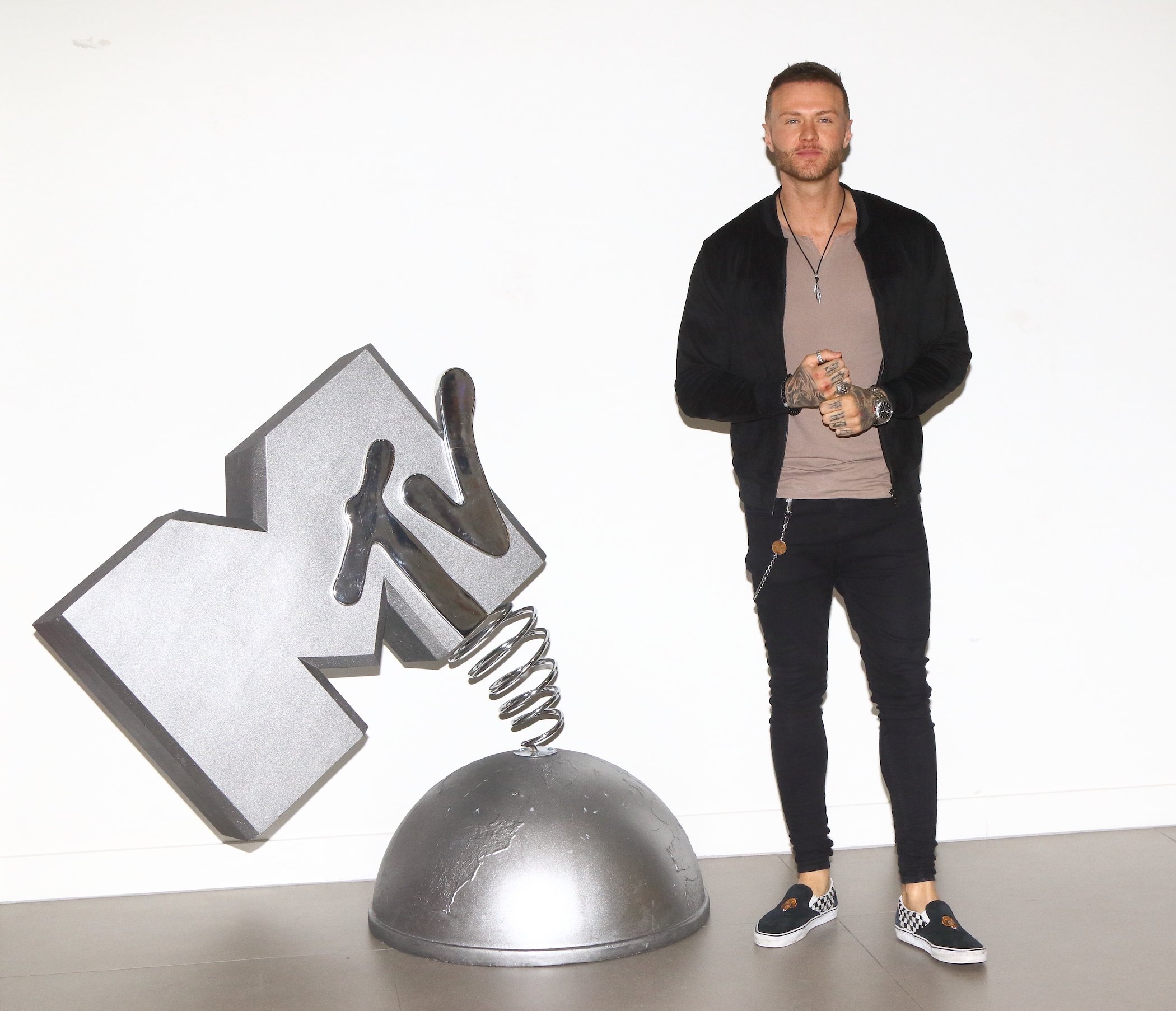 Kyle Christie from MTV’s 'The Challenge' Season 37 standing next to an MTV statue