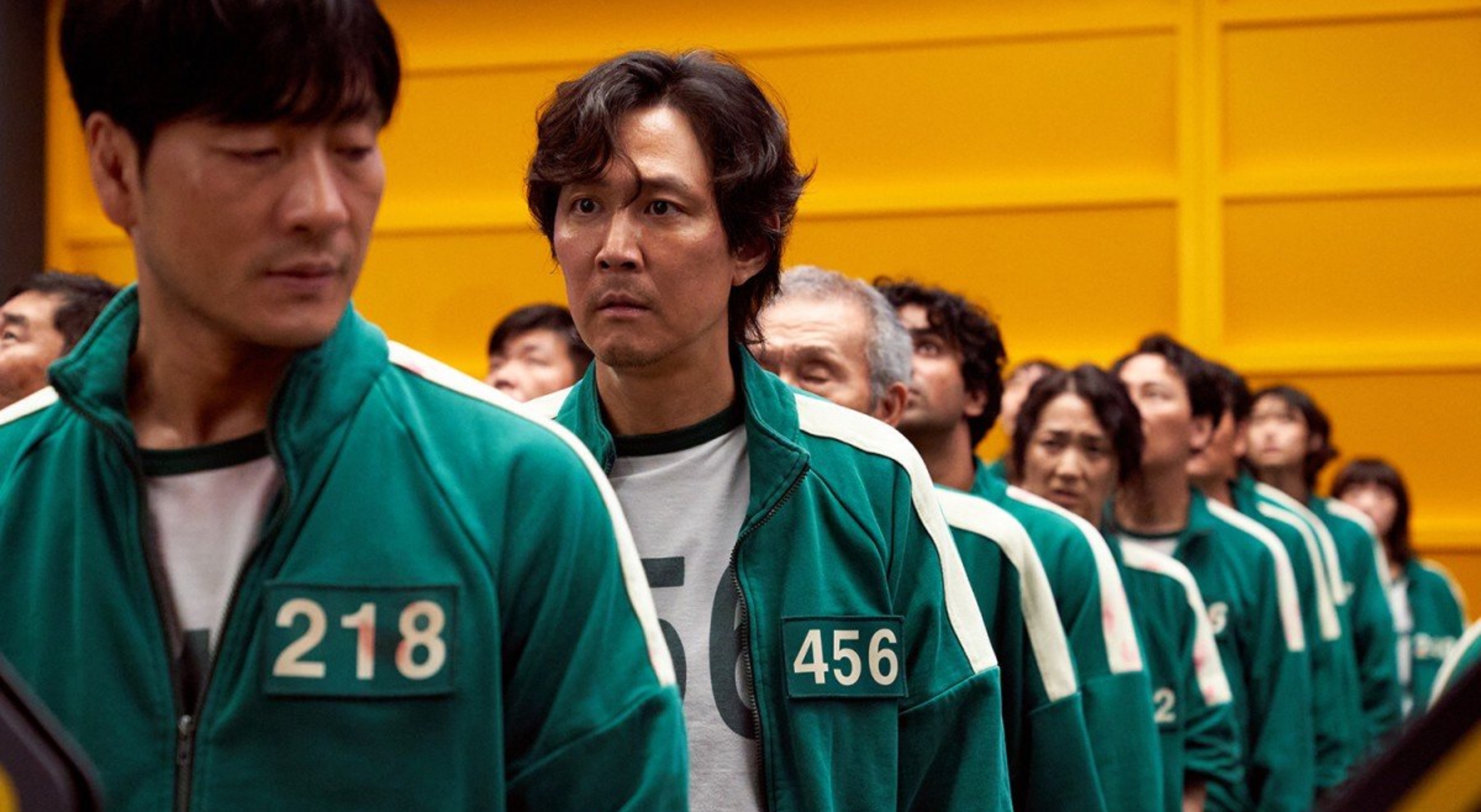 Lee Jung-Jae in Netflix's 'Squid Game' cast wearing green tracksuit in a line with other cast members