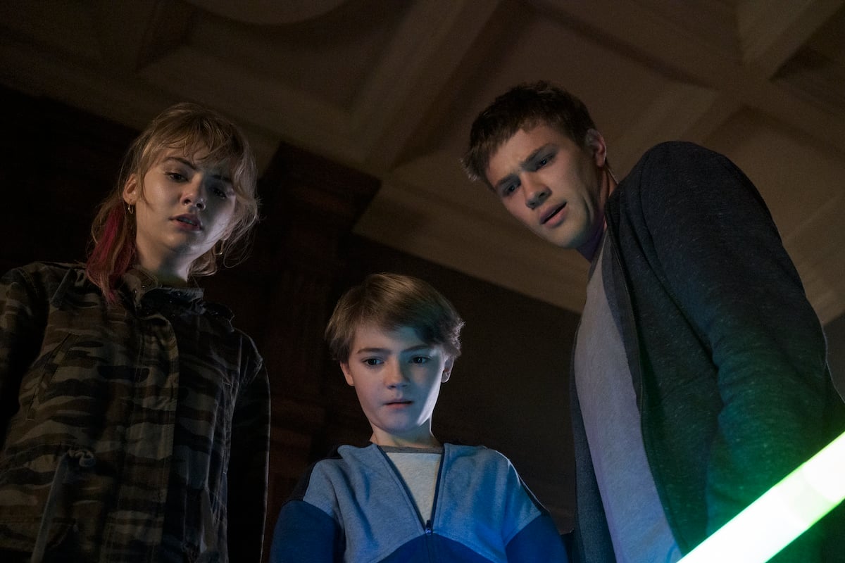 Kinsey (Emilia Jones), Tyler (Connor Jessup), and Bode (Jackson Robert Scott) look down upon something in a production still from 'Locke and Key' Season 1.