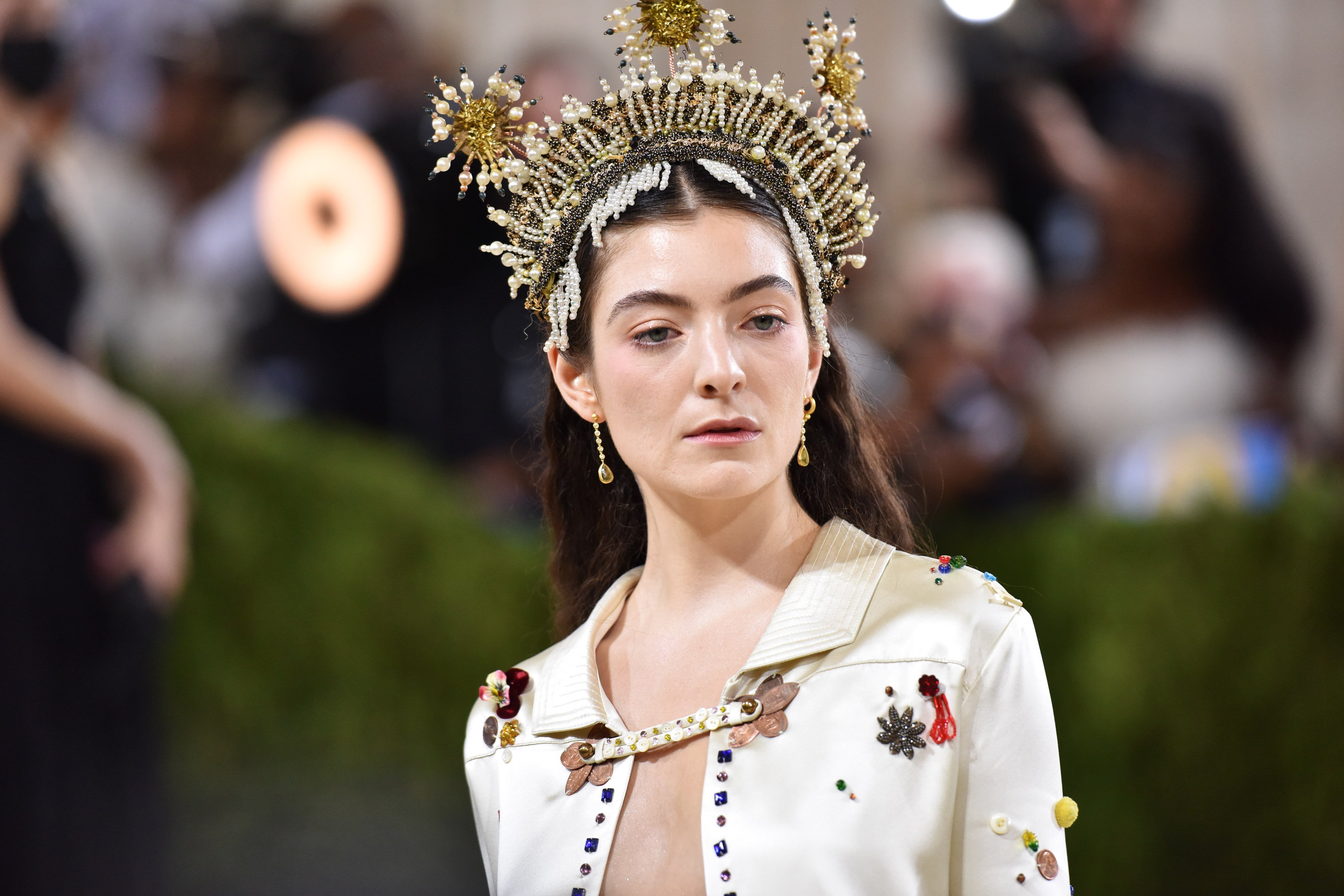 Lorde wears a headpiece and white jacket at the 2021 Met Gala