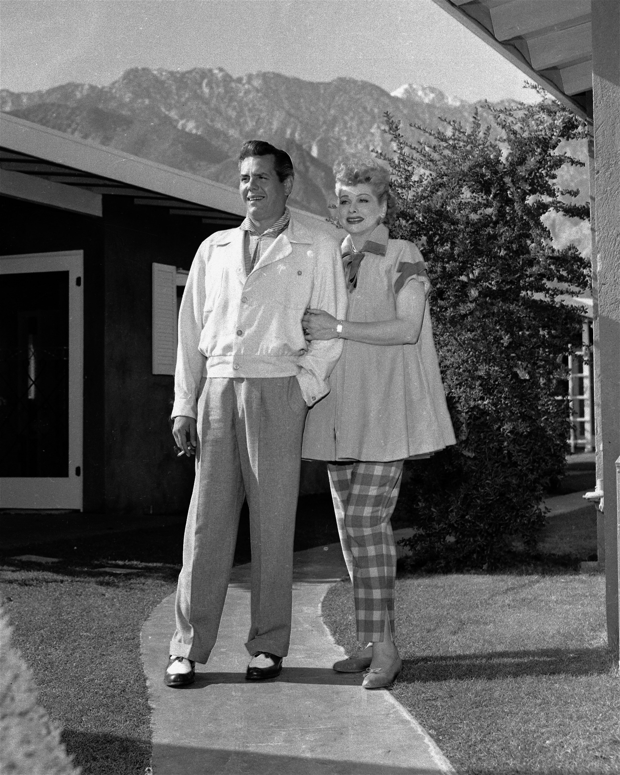 Desi Arnaz and Lucille Ball pose for a photo in front of their house during Lucille Ball's first pregnancy