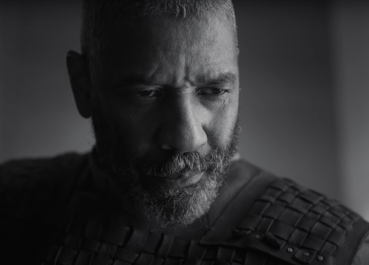 Denzel Washington as Lord Macbeth in 'The Tragedy of Macbeth' trailer. Washington wears traditional Shakespearean garb — a leather piece of armor with a long-sleeved shirt underneath — as he walks through mist with a companion behind him. The photo is in black-and-white. Washington and Frances McDormand co-star in the A24 film, written and directed by Joel Coen. The Shakespearean tragedy hits theaters Dec. 25 and Apple TV+ Jan. 14.