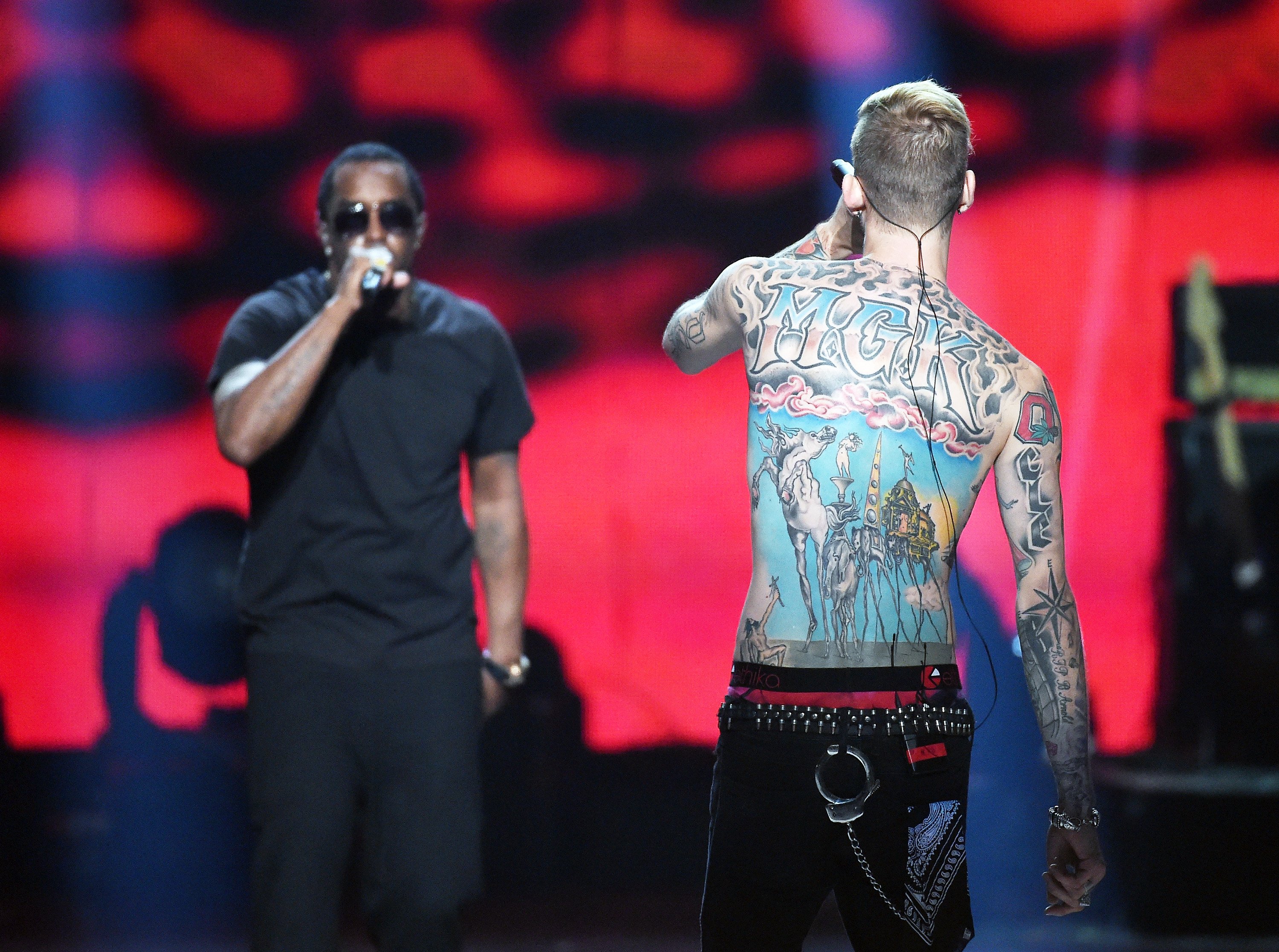 Machine Gun Kelly's back tattoo faces the camera as he performs with Sean "Diddy" Combs.