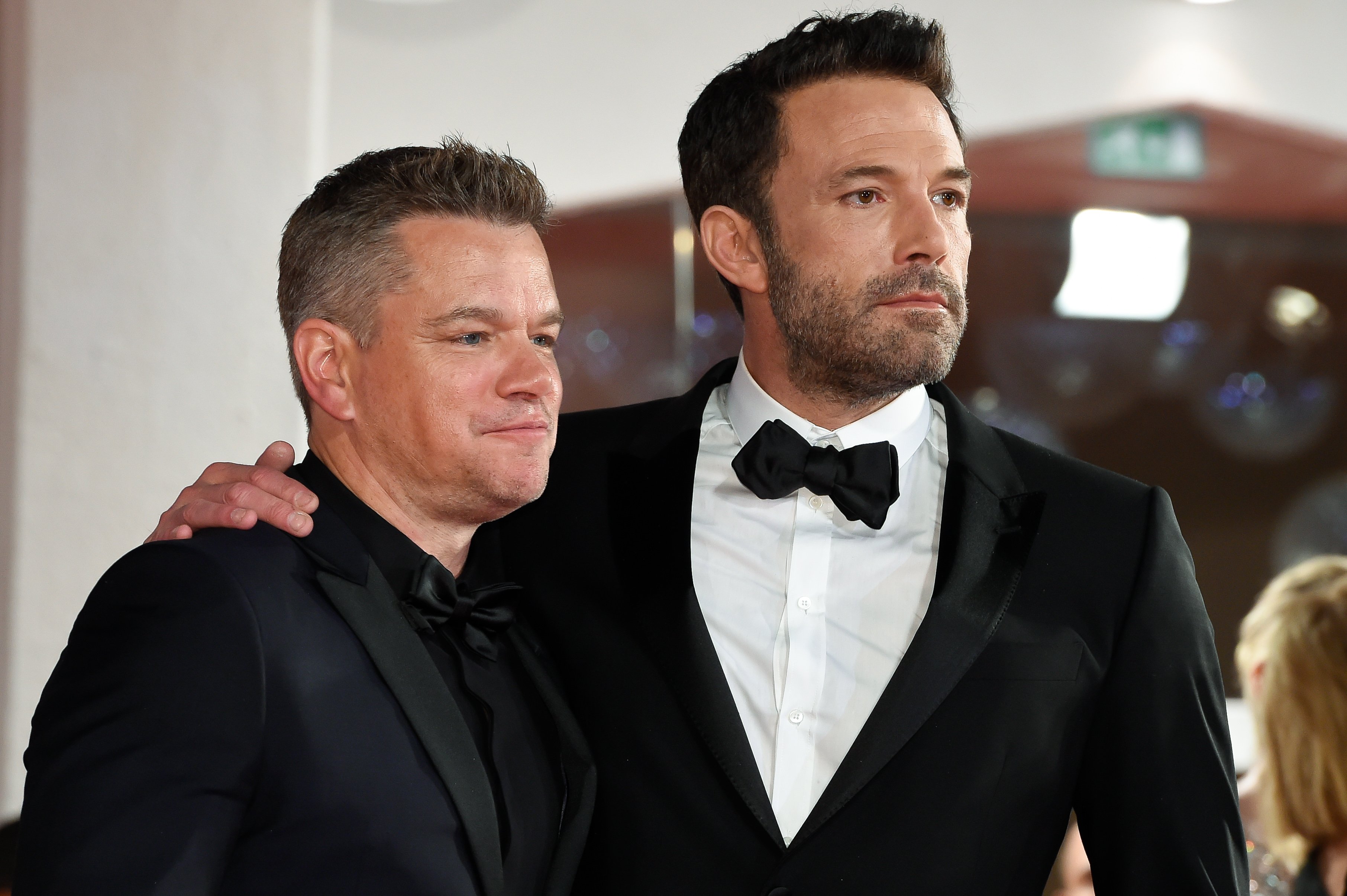 Matt Damon, in a black suit and black shirt, and Ben Affleck, in a black tuxedo, at the premiere of their film 'The Last Duel' at the Venice Film Festival in 2021.