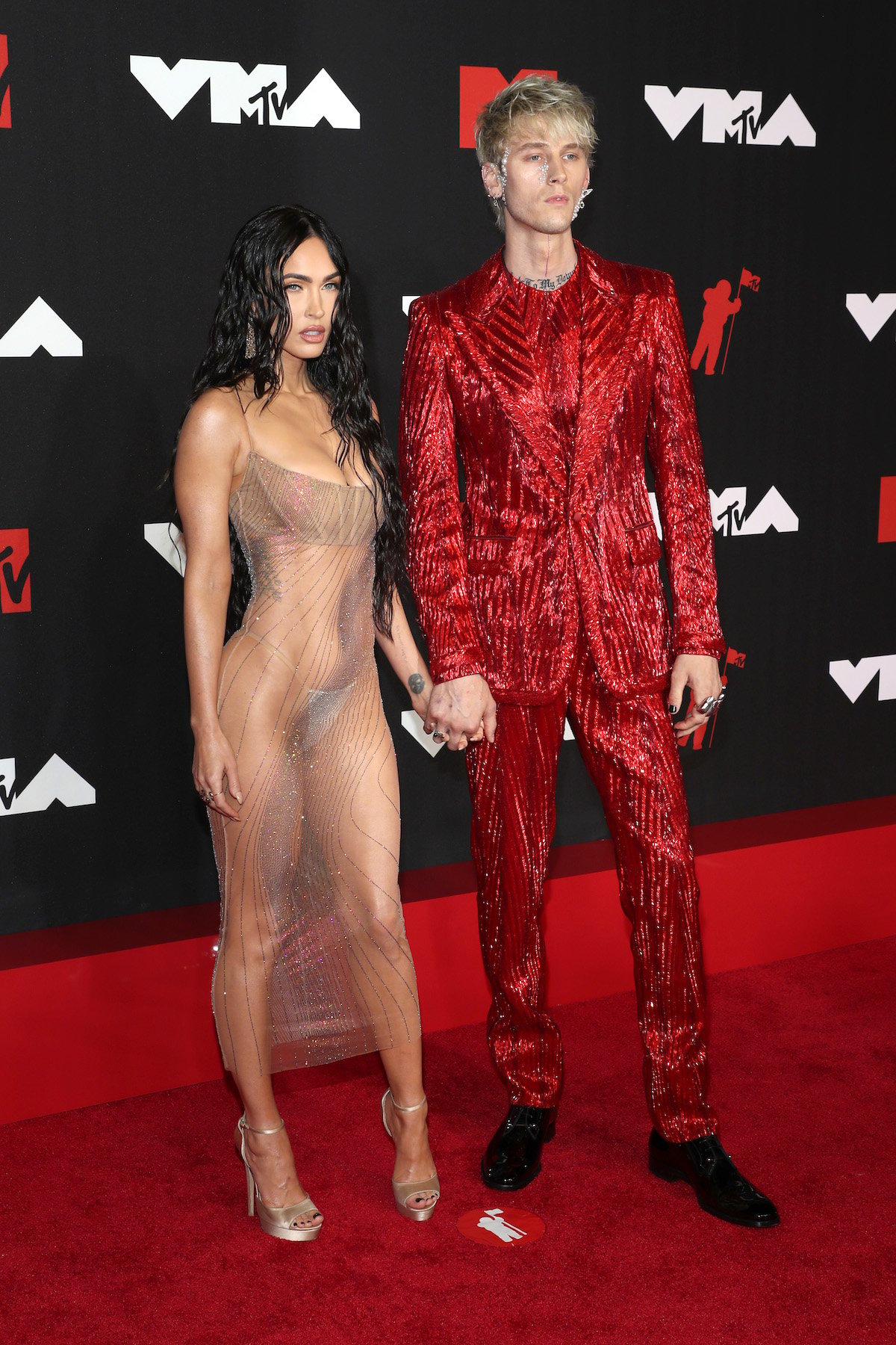 Megan Fox in a see-through dress and Machine Gun Kelly in a red sequined suit at the 2021 VMAs.