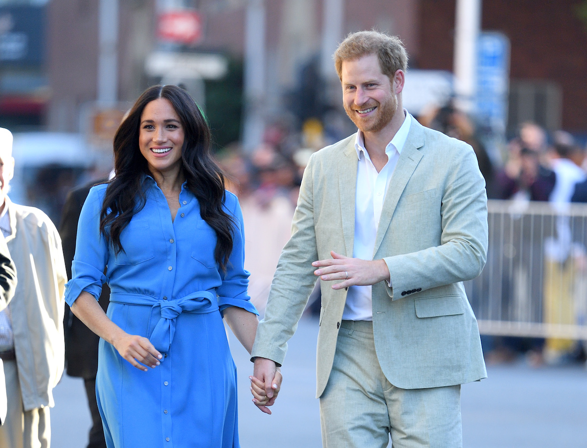 Meghan Markle and Prince Harry holding hands, smiling