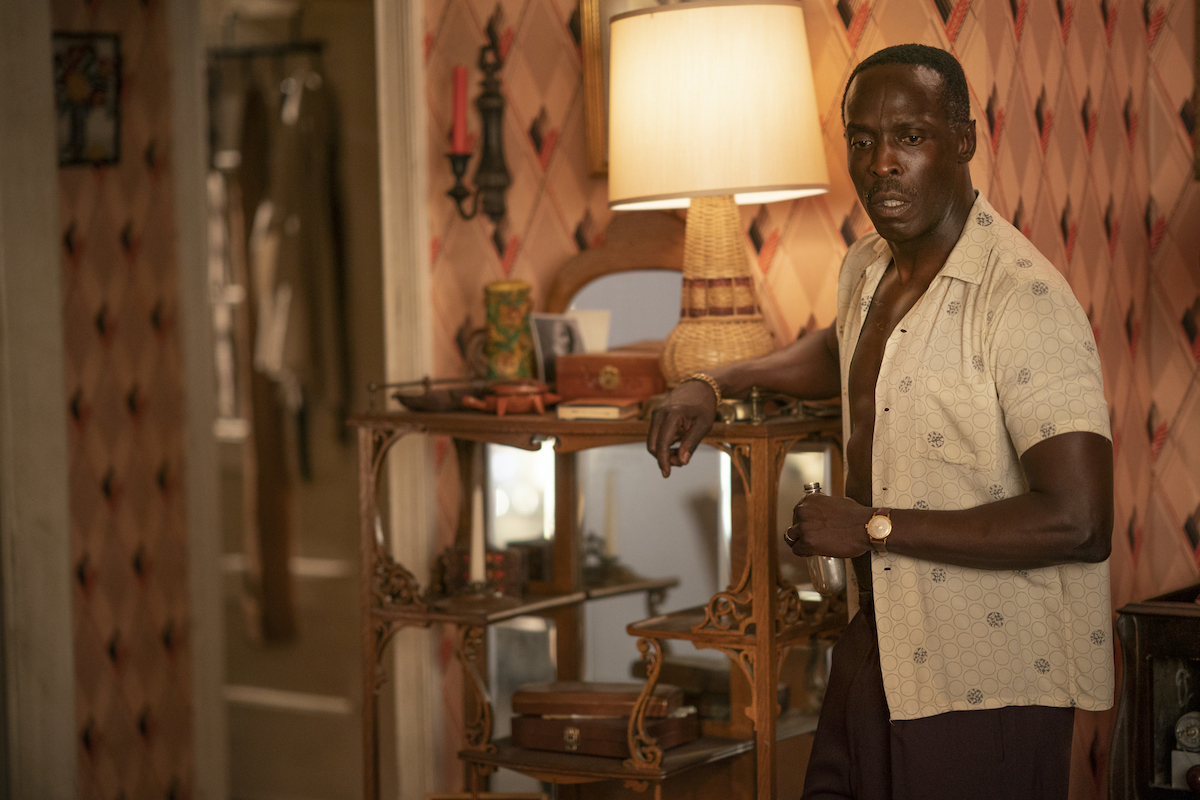 Michael K Williams standing in a bedroom with his shirt unbuttoned in 'Lovecraft Country' Season 1.