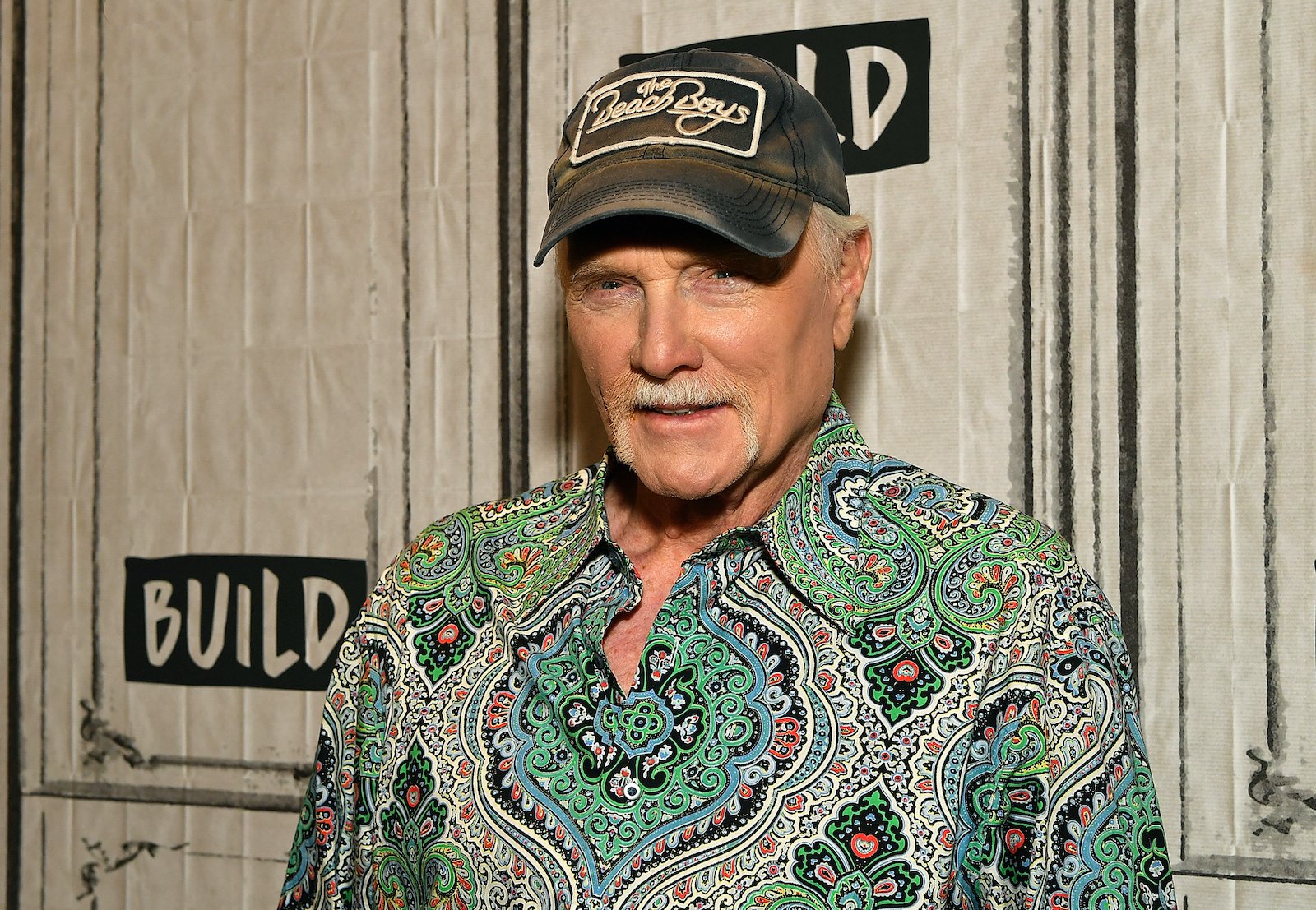 Mike Love of The Beach Boys in front of a white background