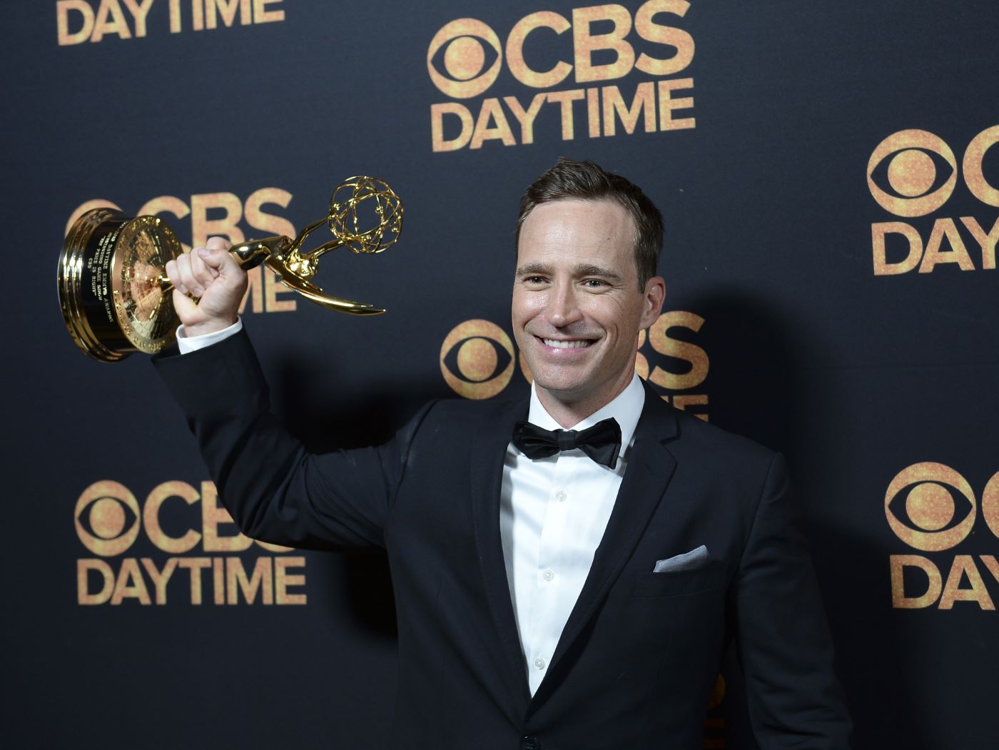 Mike Richards dressed in a suit in front of a dark blue background with 'CBS Daytime' written in gold and the logo displayed.