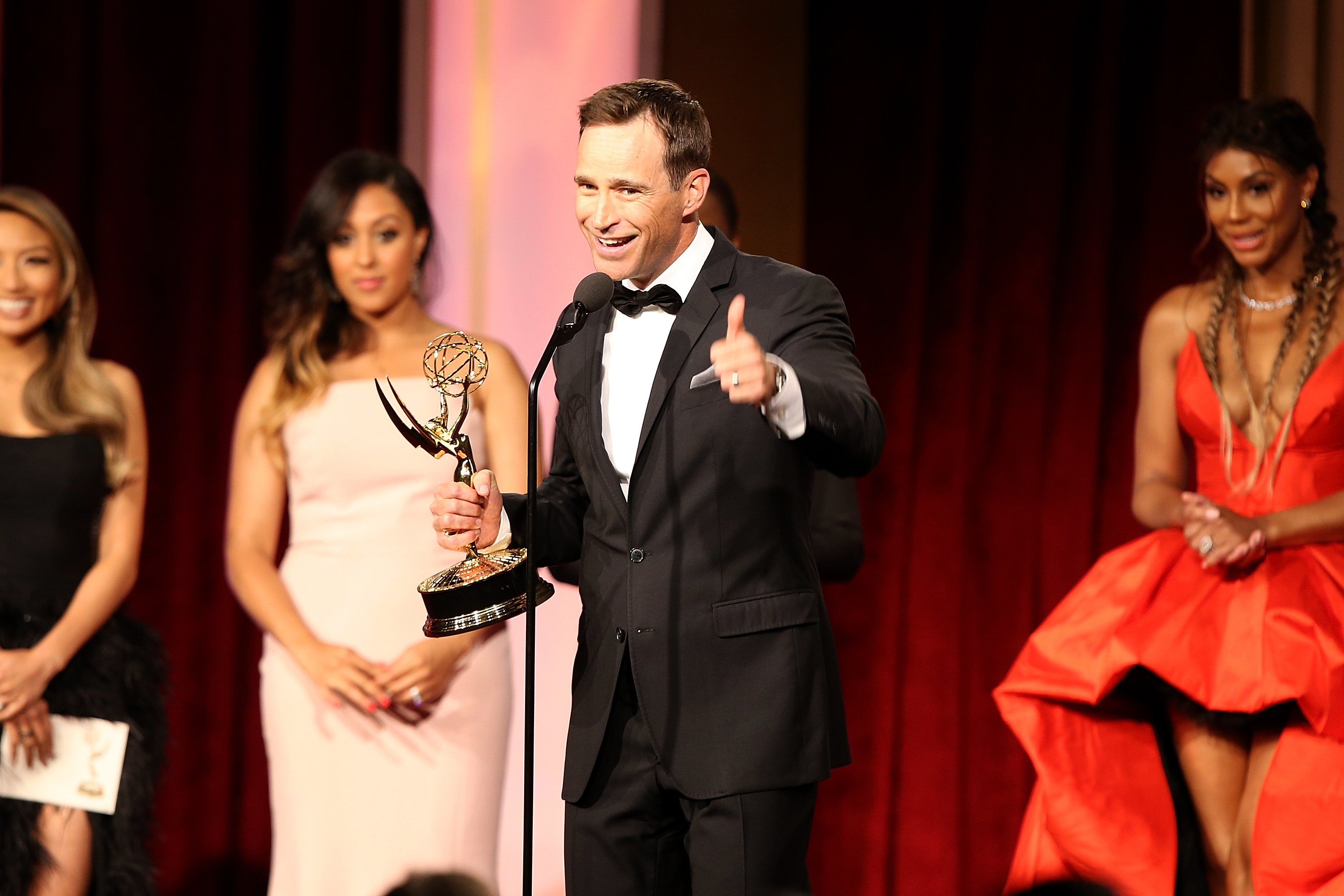 Richards stands onstage in a tuxedo, accepting a Daytime Emmy Award.